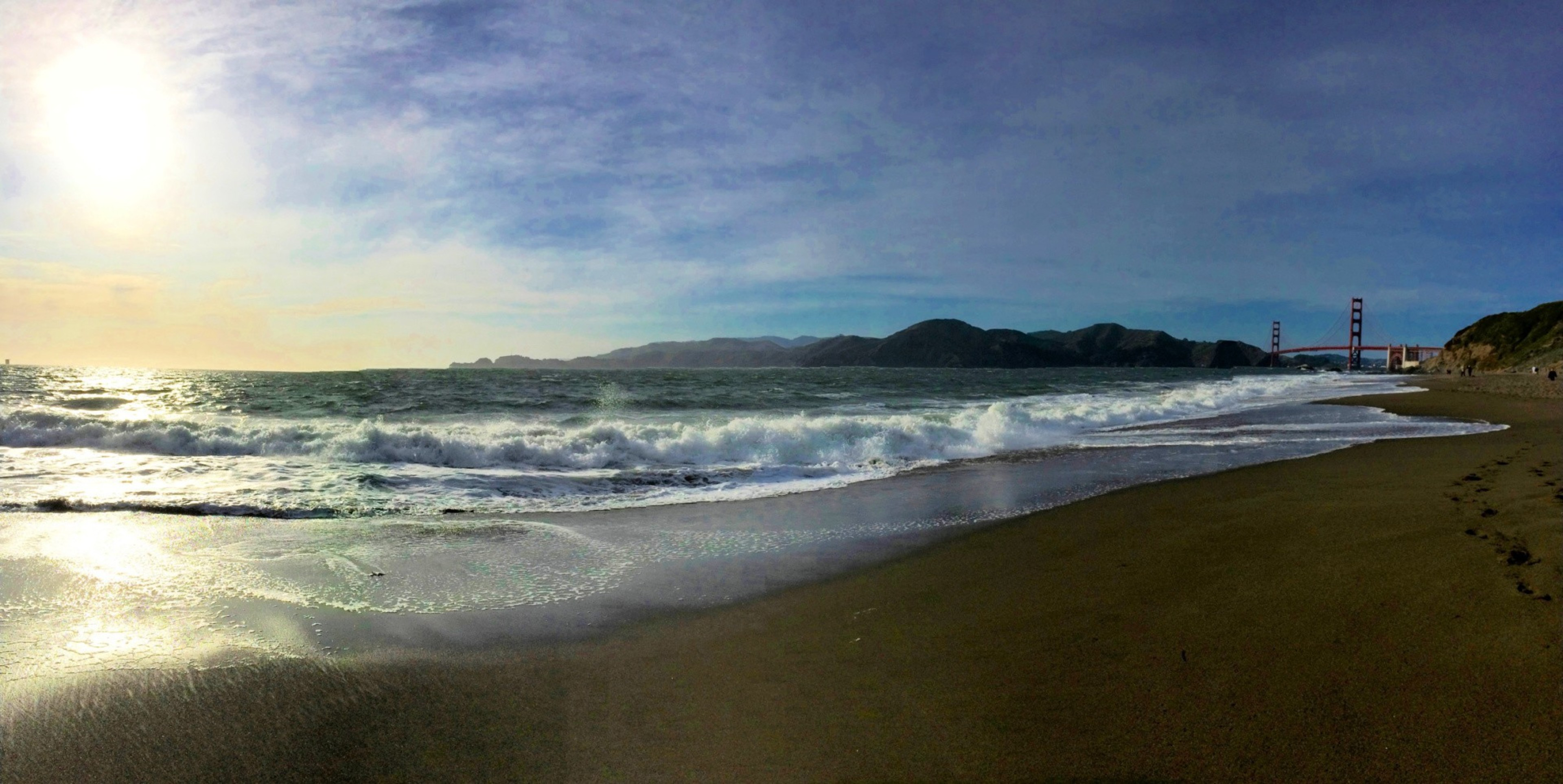 Sun shines on the beach causing glare off the waves.