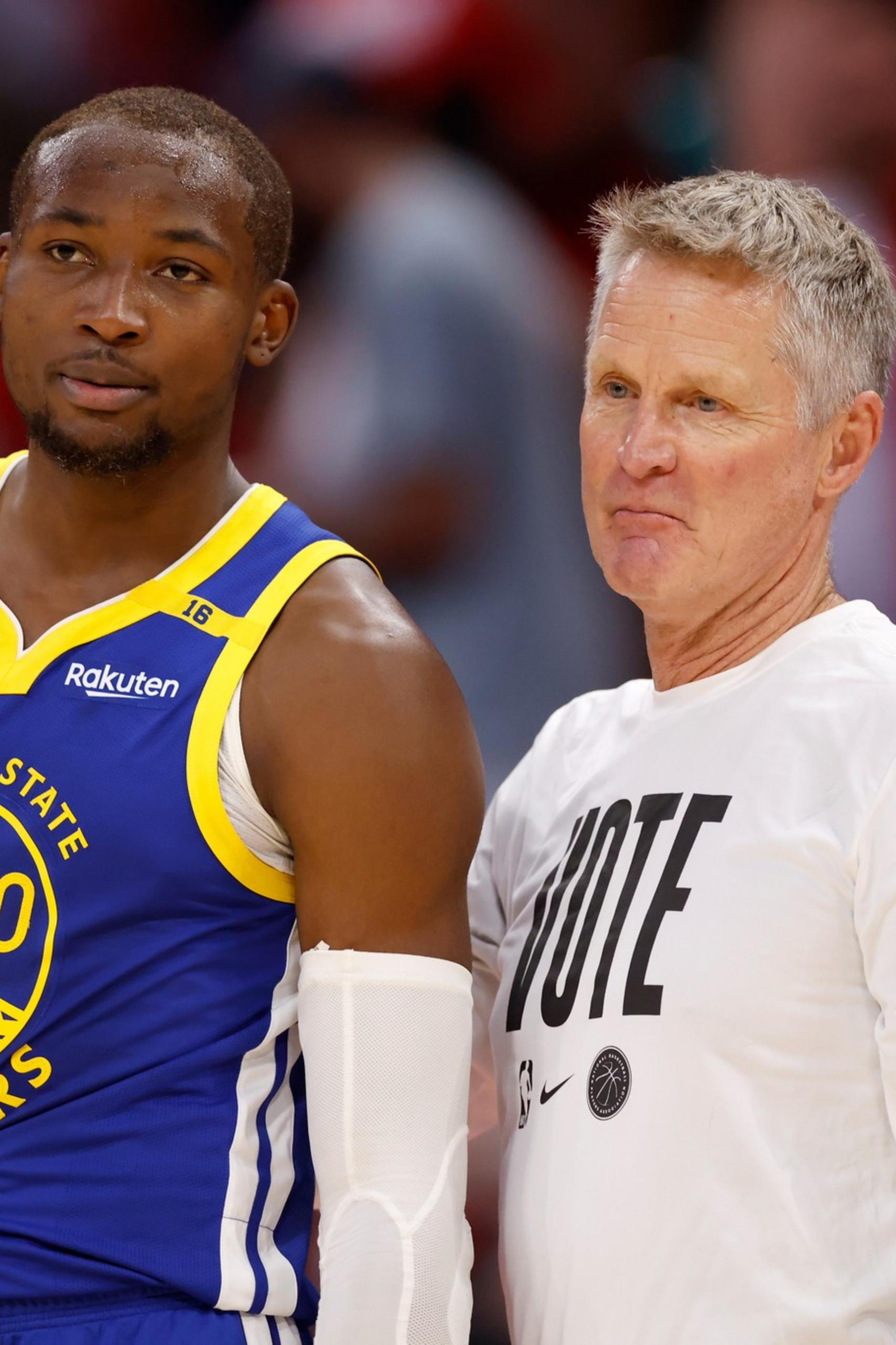 A Golden State Warriors player in a blue jersey stands next to a man in a white "VOTE" shirt, both looking ahead with serious expressions.