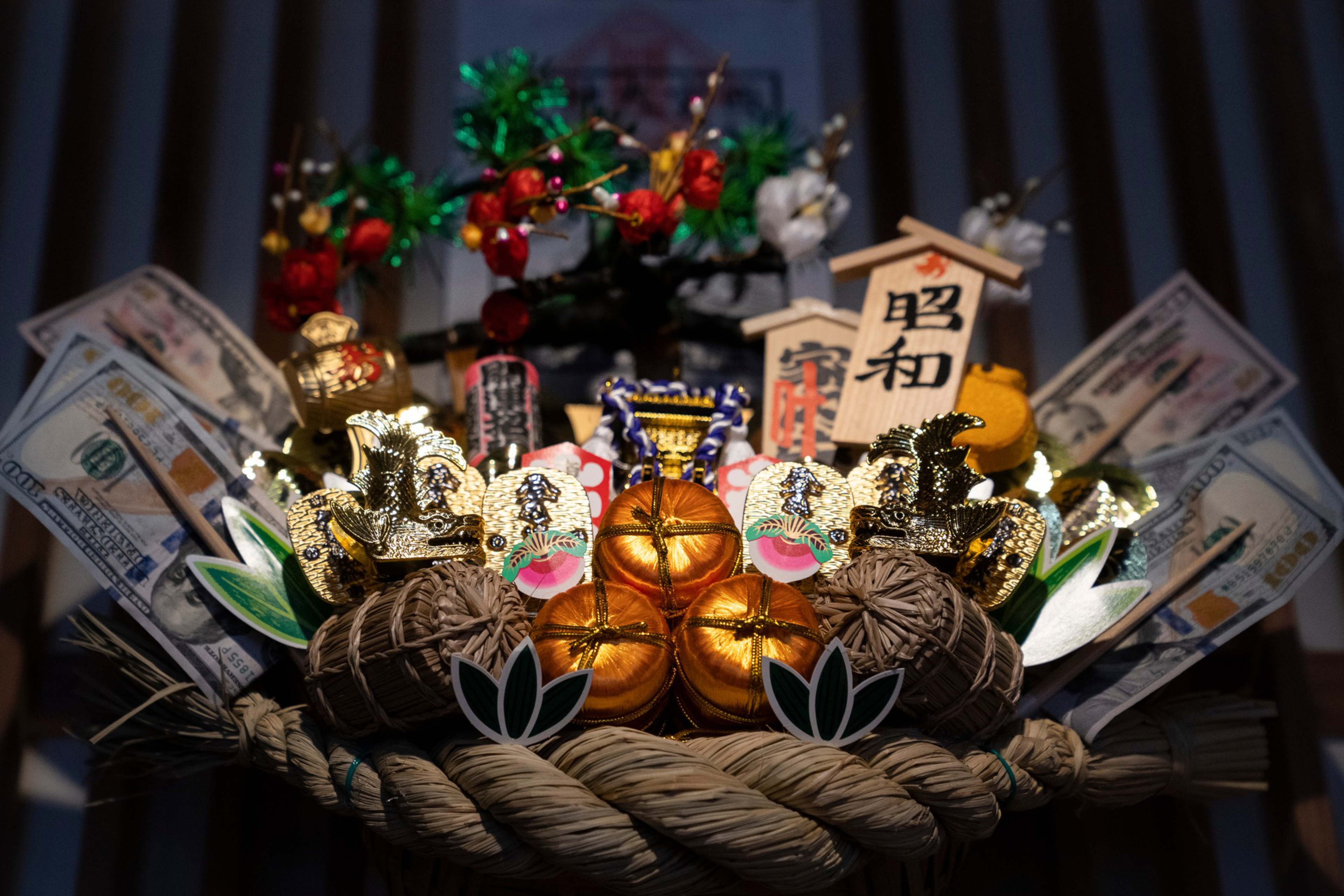 The image shows a decorative Japanese &quot;kumade&quot; rake, adorned with gold accents, money, miniature decorations, and small wooden plaques, symbolizing good fortune and prosperity.