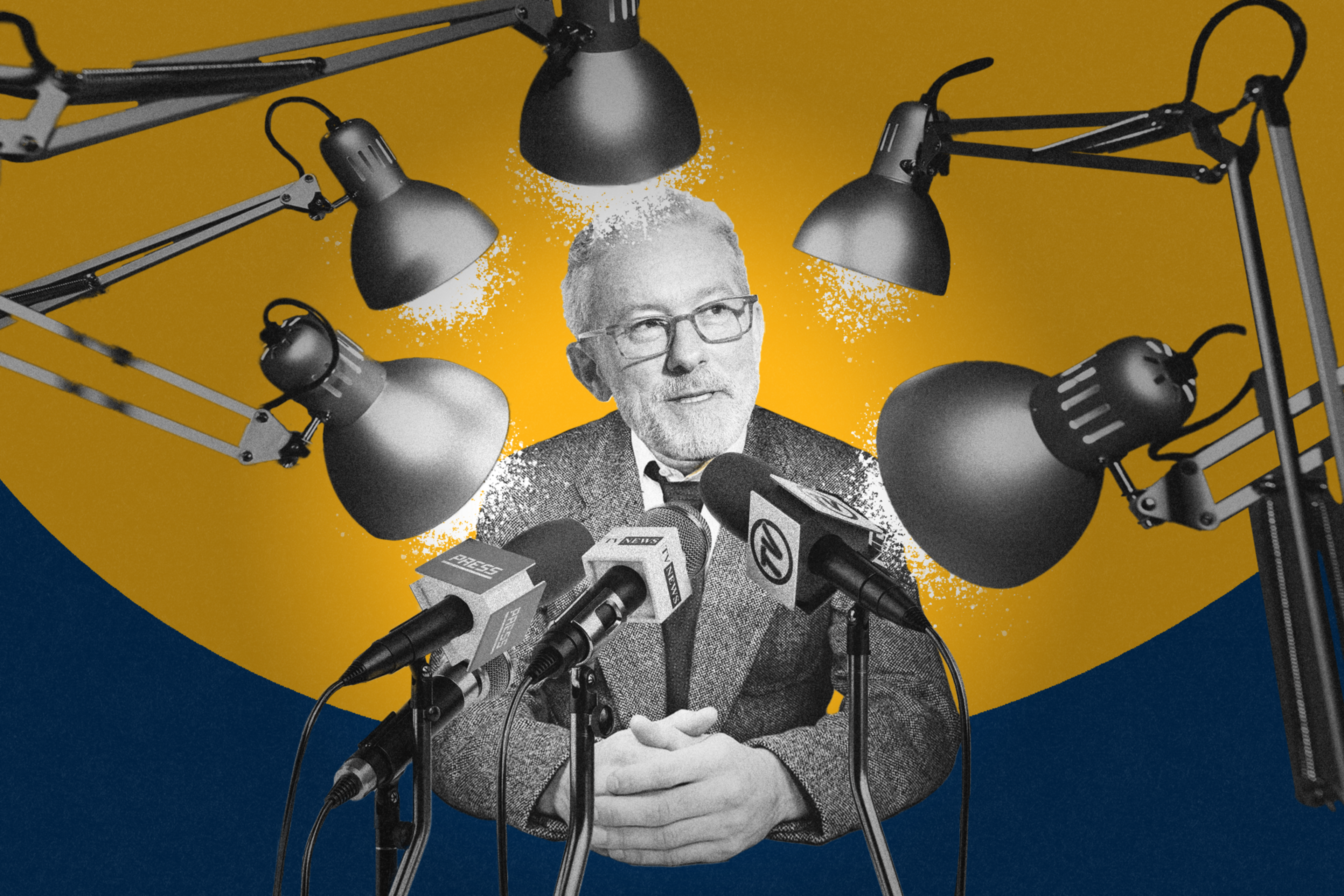 A man with glasses sits at a table surrounded by microphones, with multiple desk lamps aimed at him. The background is a blend of blue and yellow.