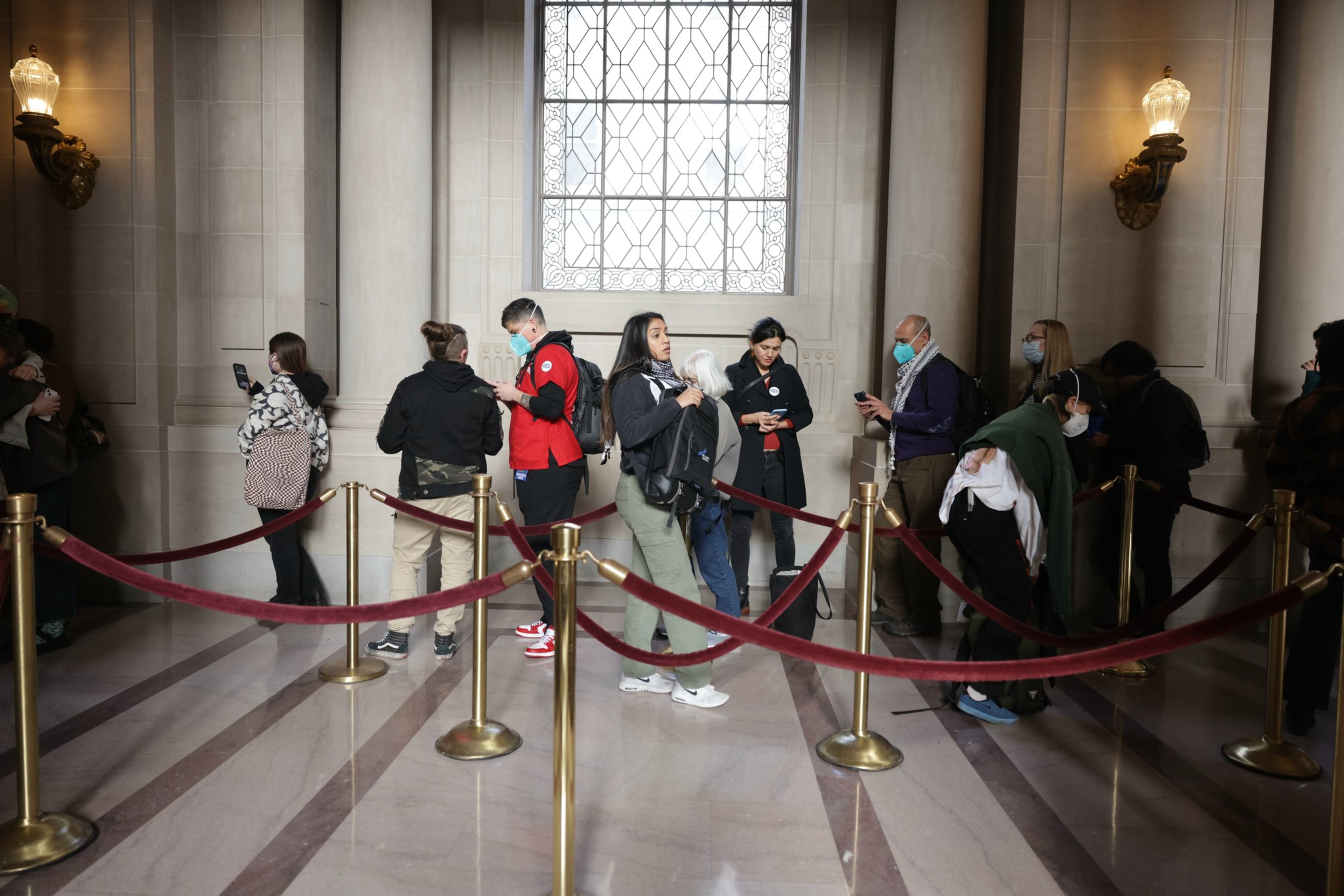 People wait in line to enter the Board of Supervisors meeting.