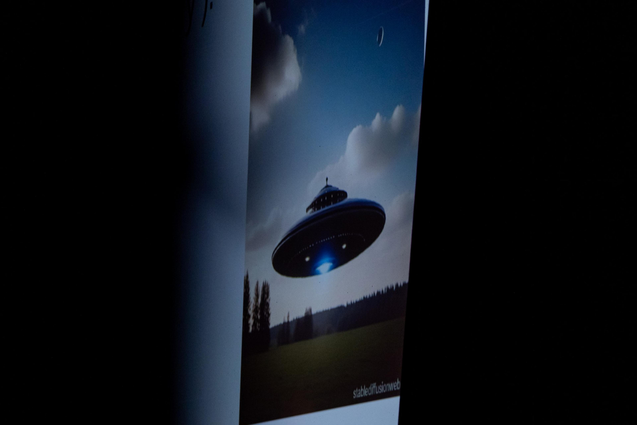 The image shows a UFO hovering over a grassy field with trees and a partly cloudy sky in the background. There's a small moon visible in the sky.