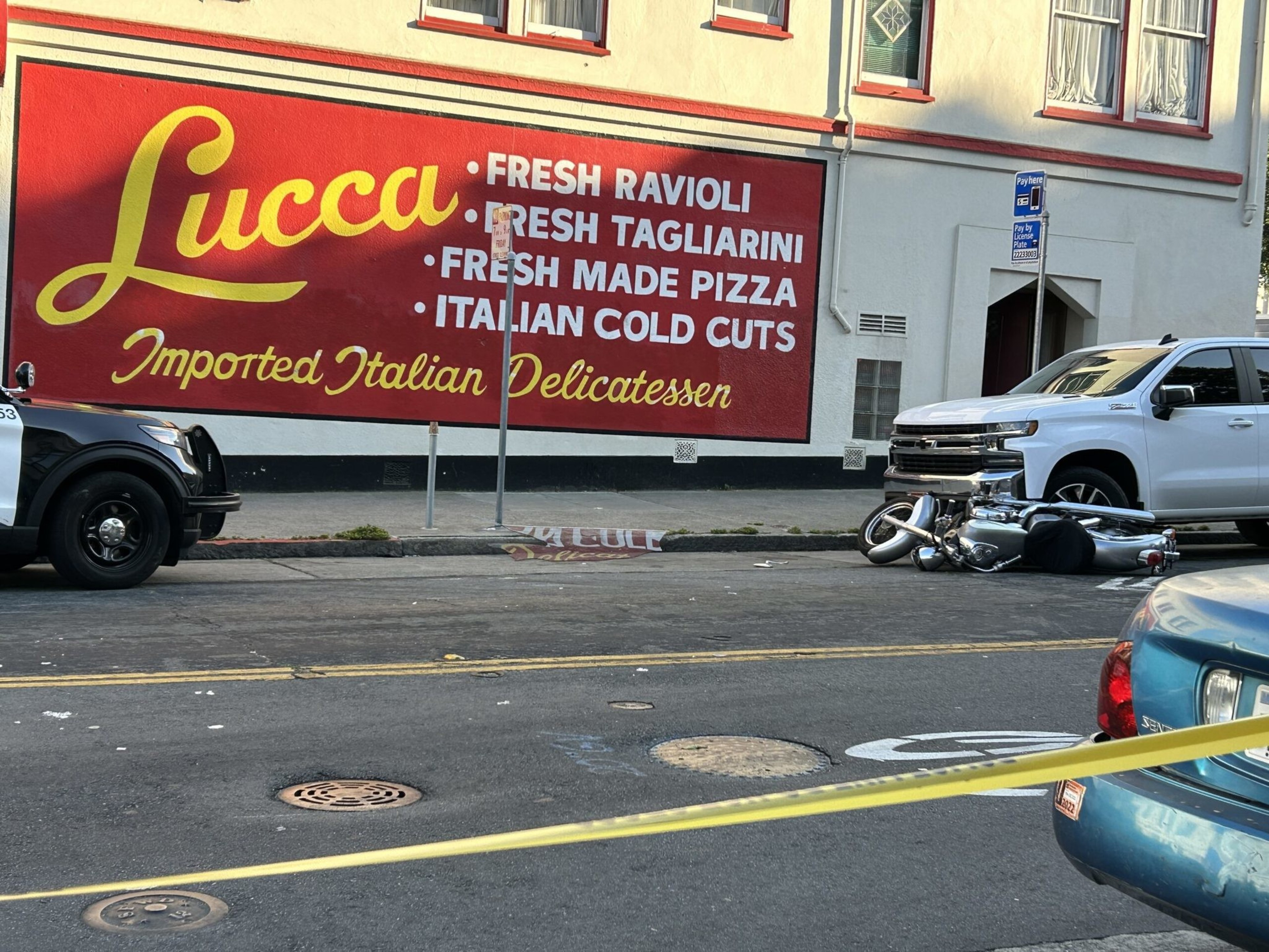 A San Francisco police vehicle is wedged into the entrance of the former Lucca Ravioli at 22nd and Valencia streets in the Mission District on Wednesday. | Astrid Kane/The Standard