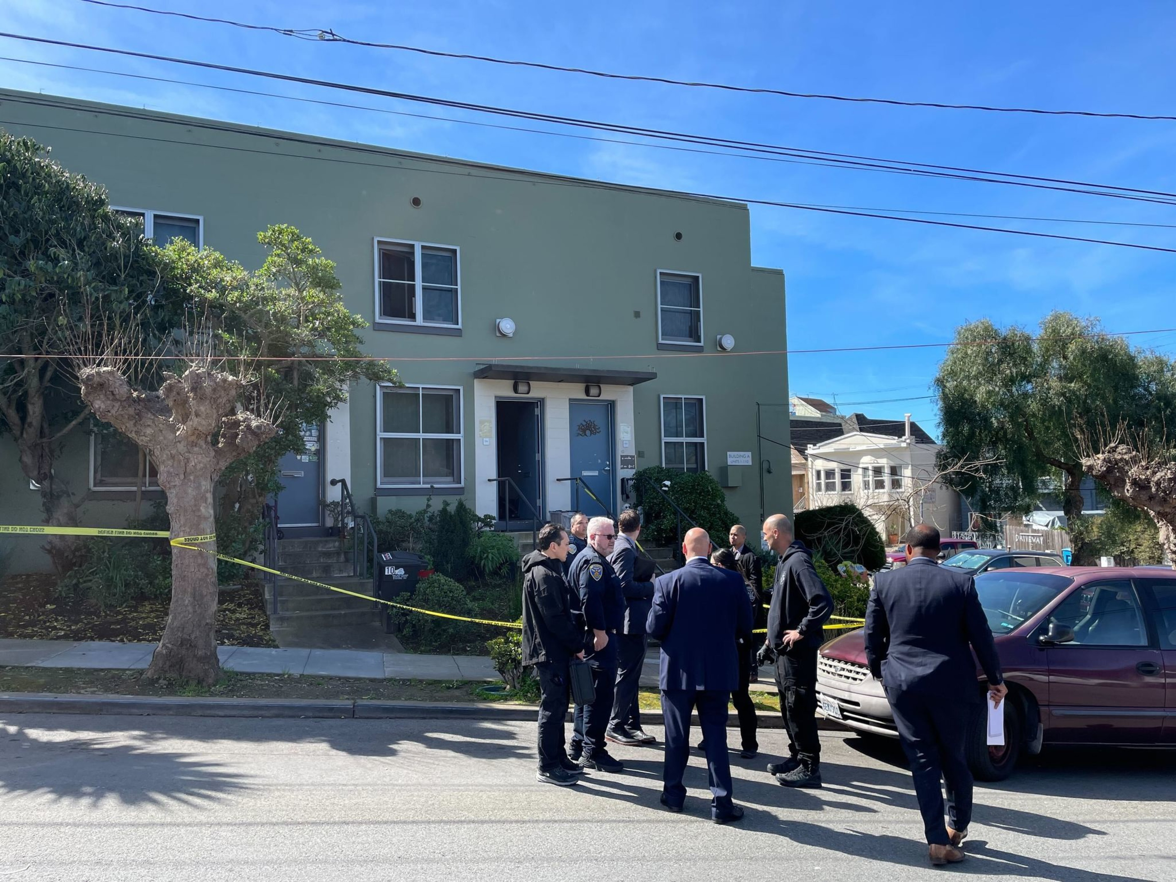 Police officers gather outside a home.