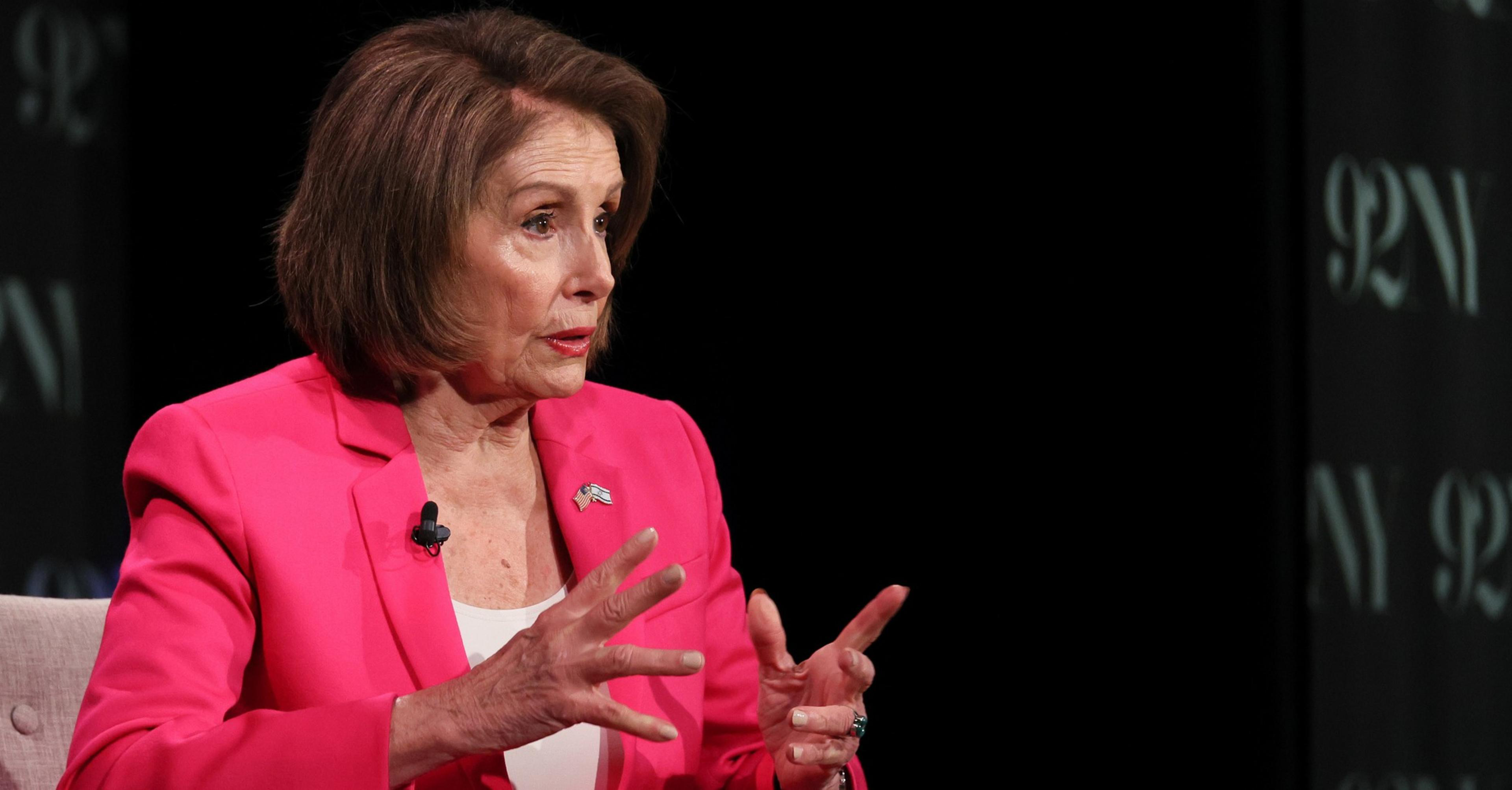 A woman in a pink blazer gestures while speaking, with a blurred 92Y logo in the background.