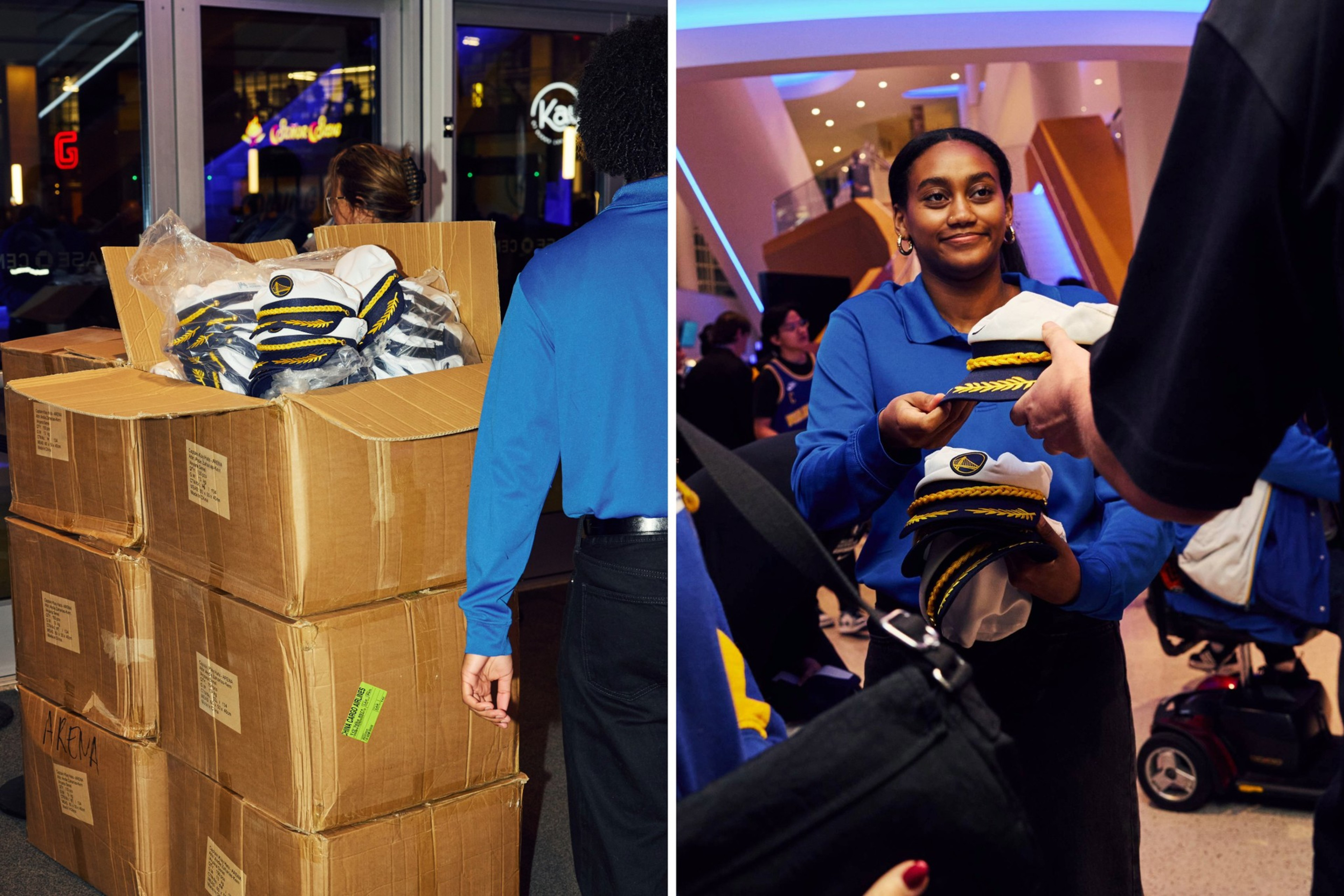 People in blue shirts distribute navy captain hats from large boxes inside a busy lobby with bright lighting.