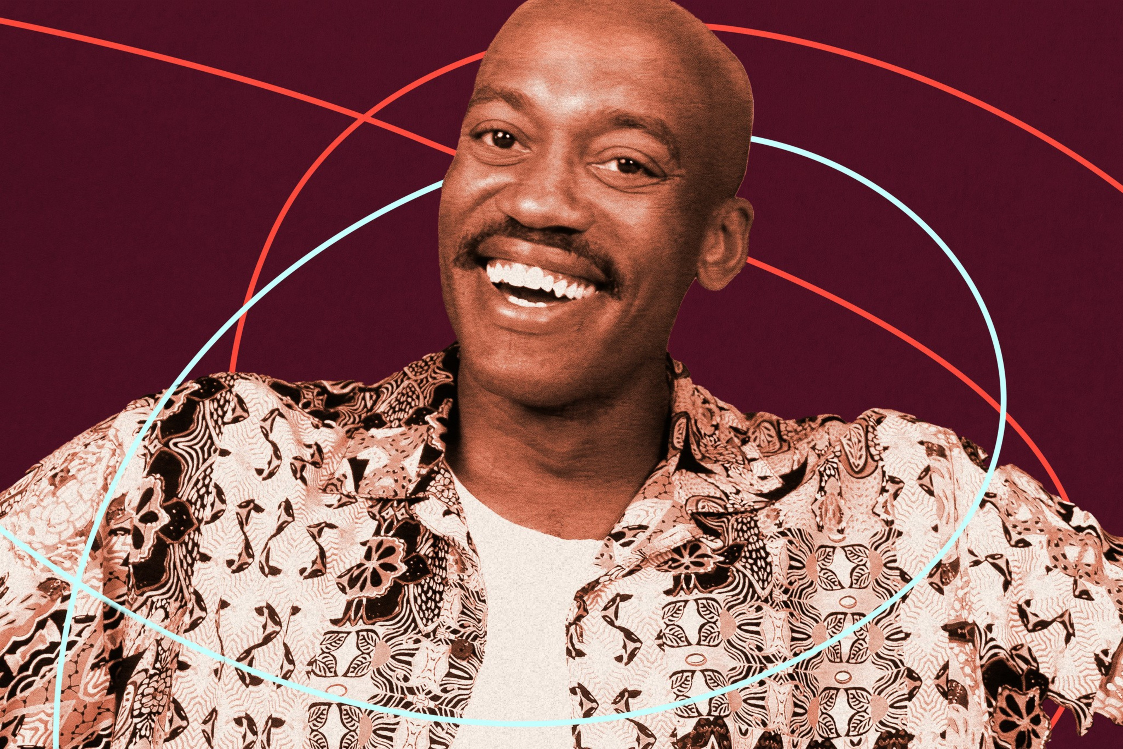 A smiling man with a bald head and mustache wears a patterned shirt against a maroon background with red and light blue curved lines.