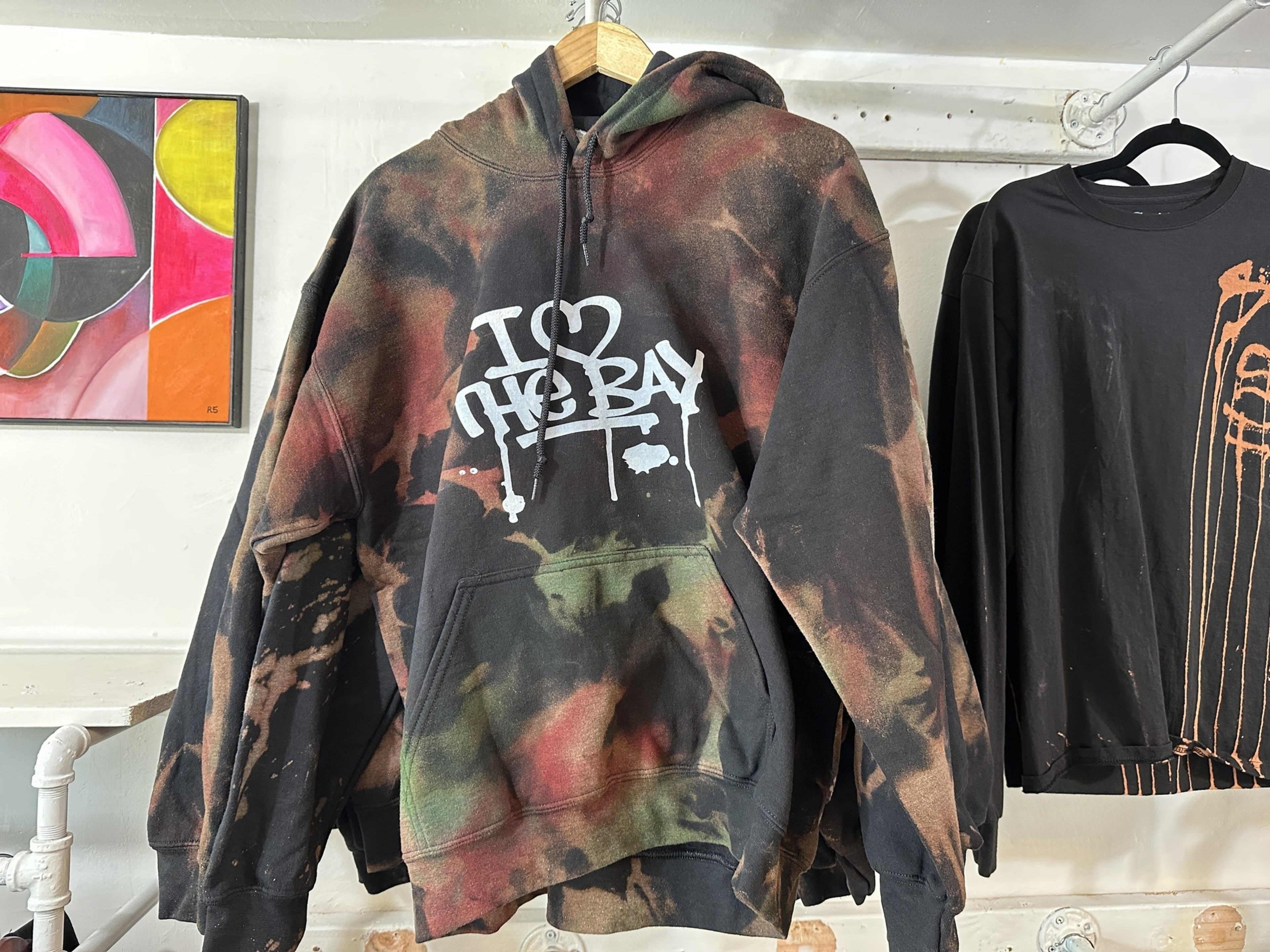 A hoodie with &quot;I Love the Bay&quot; graffiti lettering hangs in an art and apparel shop on Valencia Street in San Francisco.