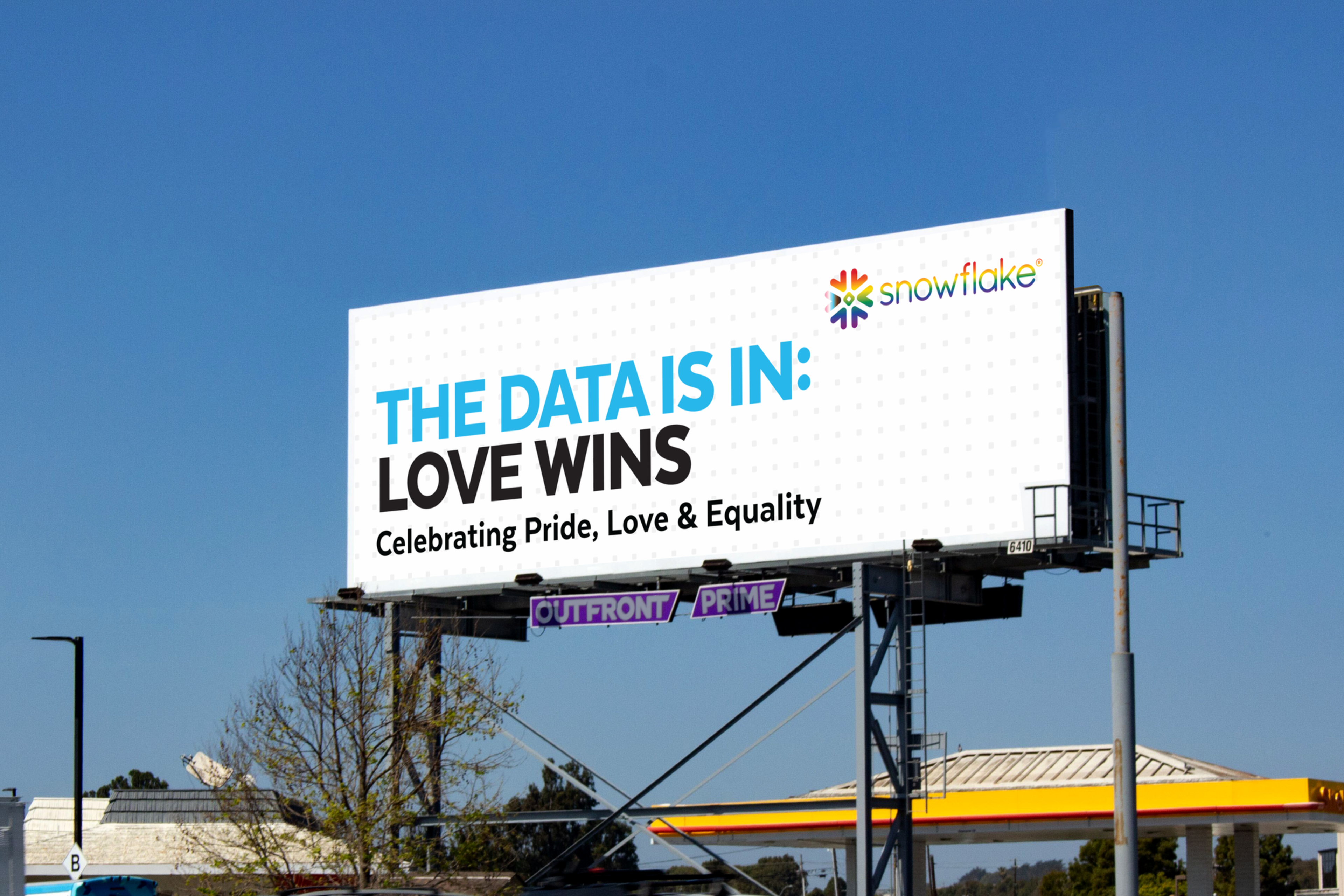 A billboard displays the message "THE DATA IS IN: LOVE WINS" in blue and black text, promoting "Celebrating Pride, Love & Equality" with the Snowflake logo.