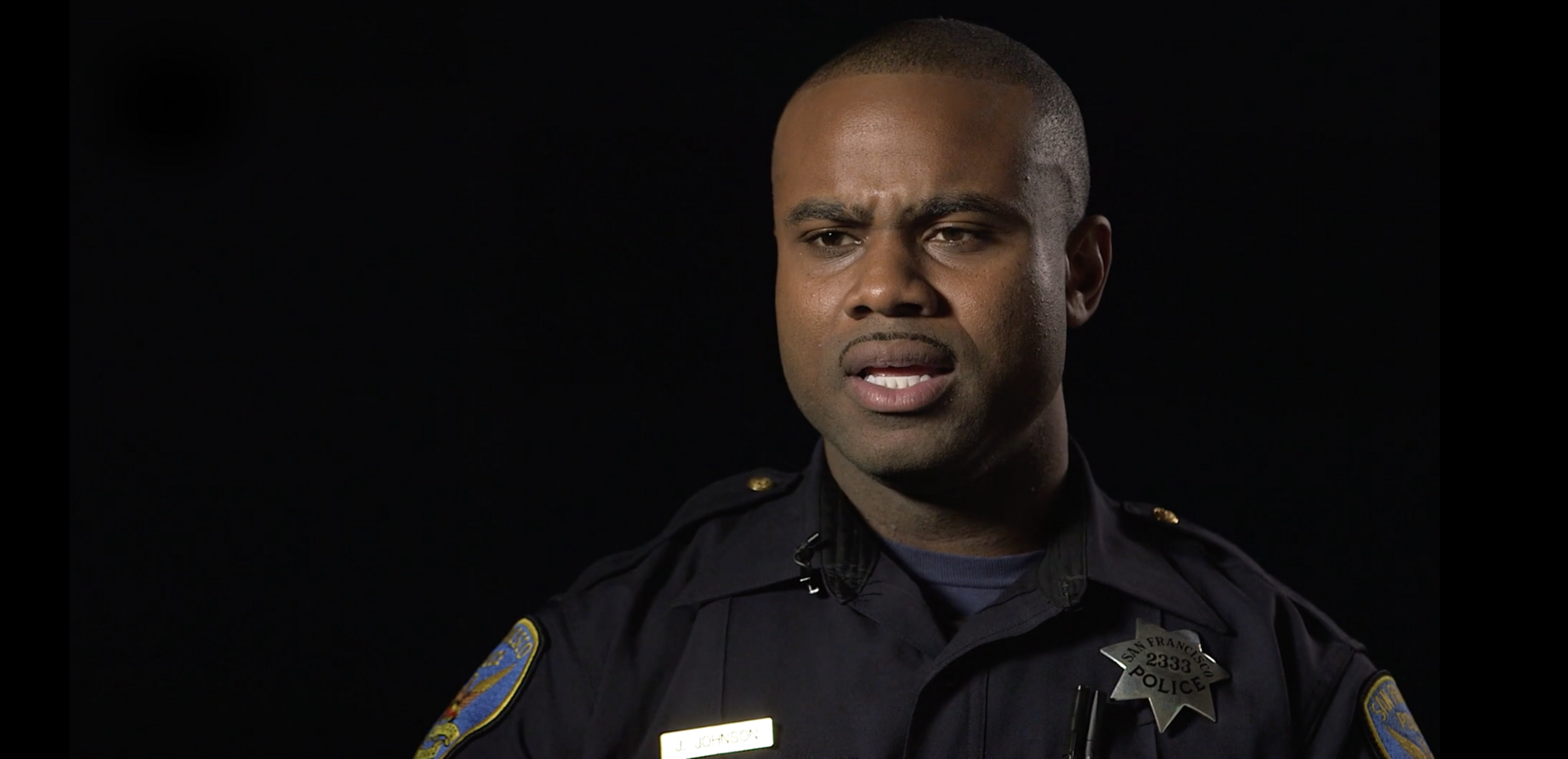 A police officer faces a camera.