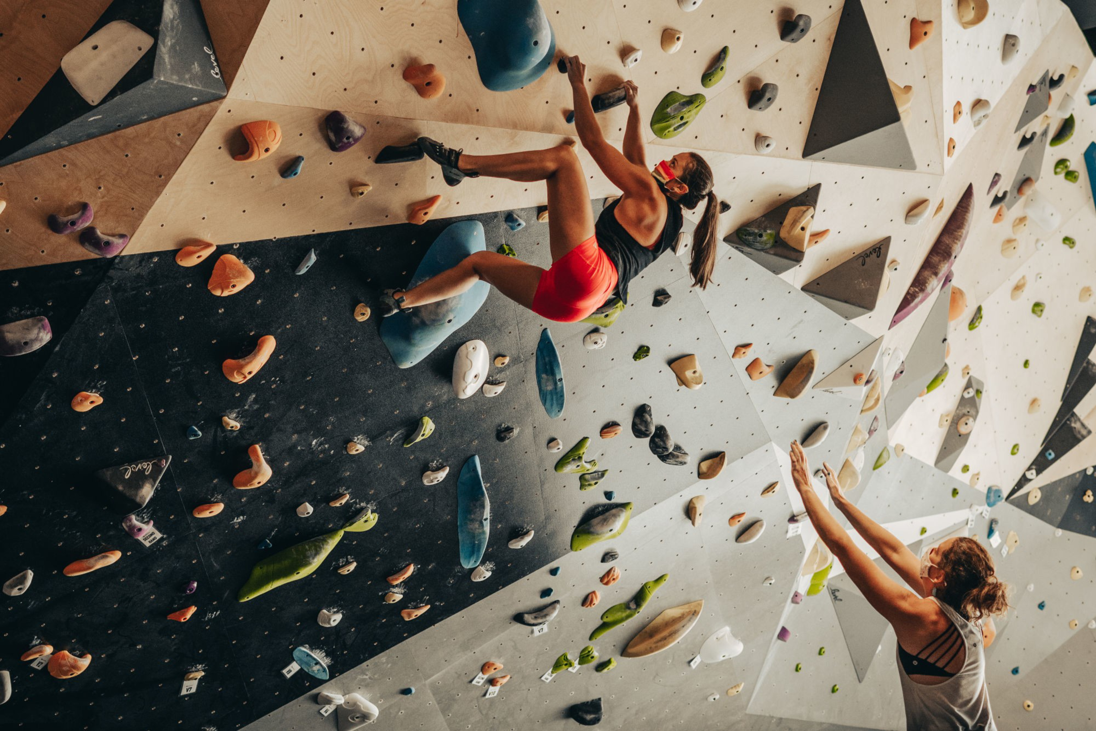 Two women on a climbing wall.