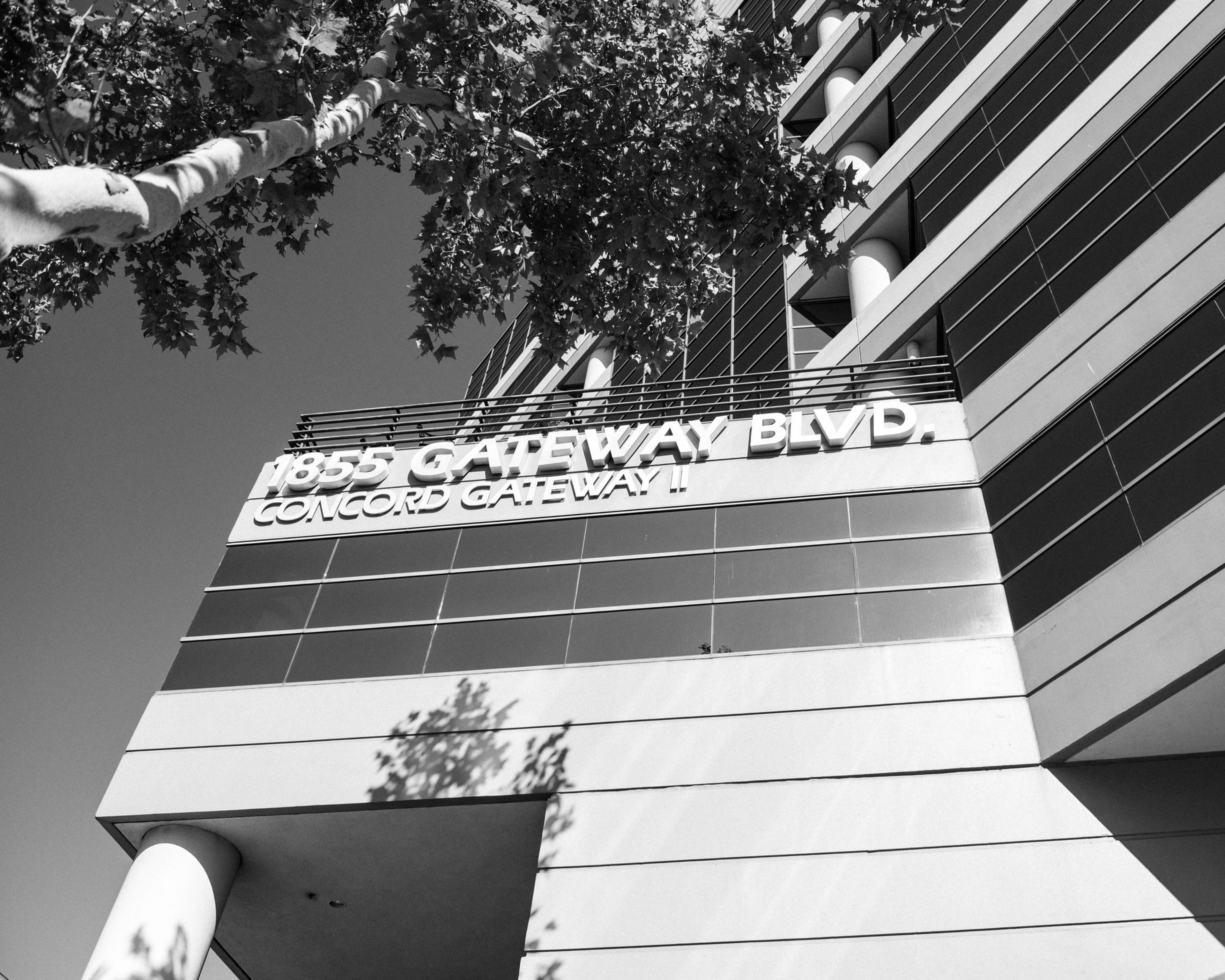 A multi-story building with horizontal stripes displays a sign reading ...