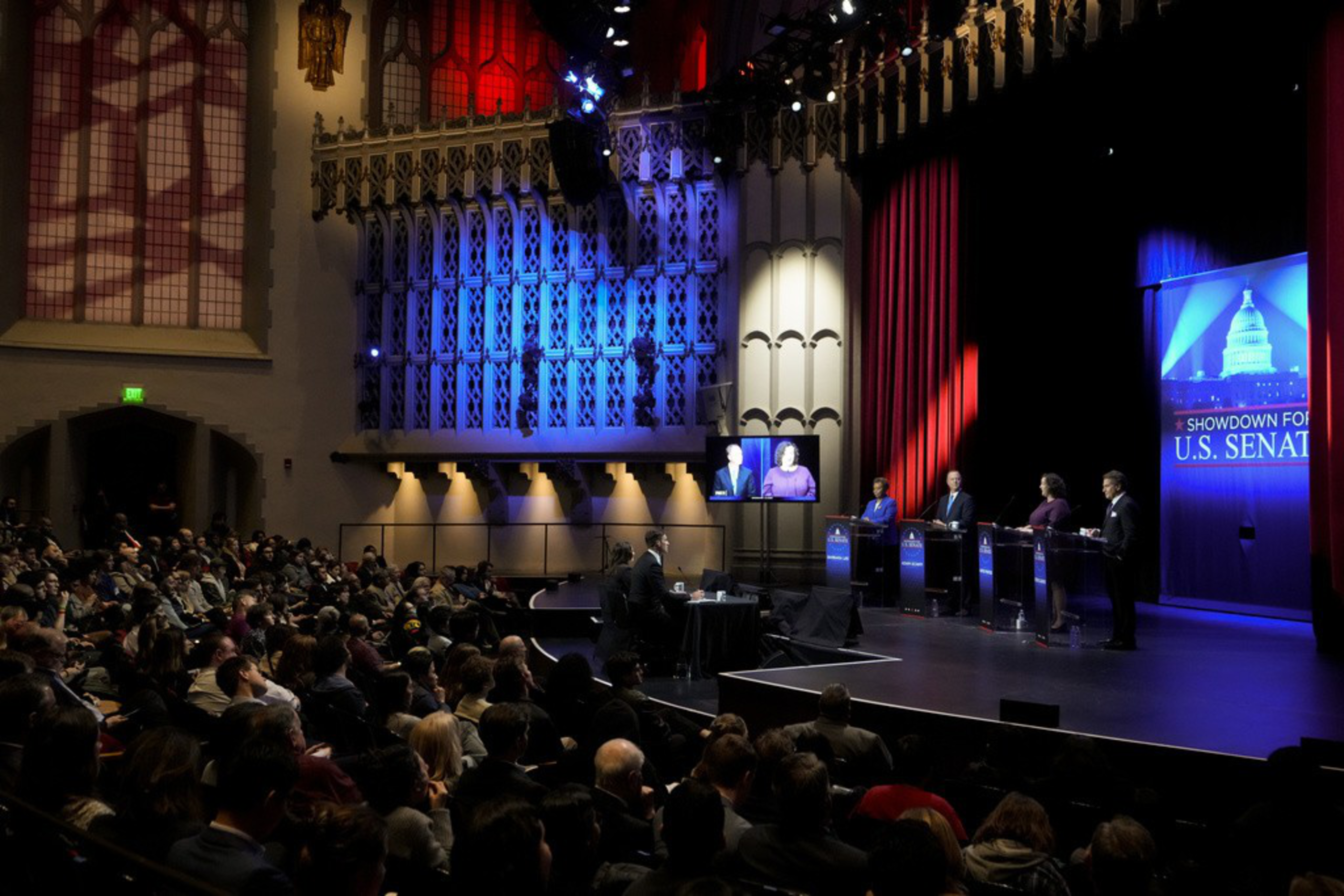 Four people on stage in front of a sign saying &quot;Showdown for U.S. Senate.&quot;