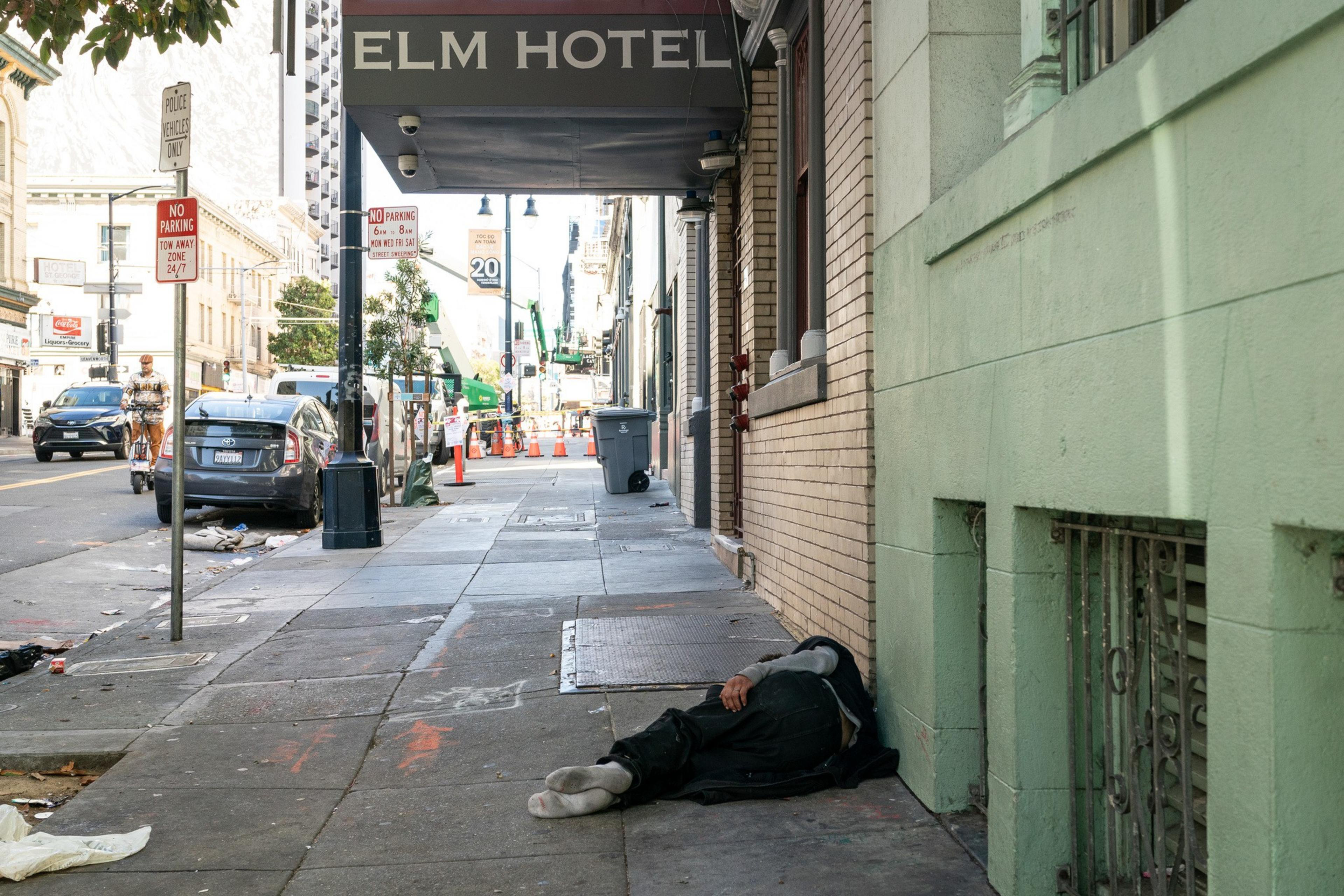 A person laying on the sidewalk. 