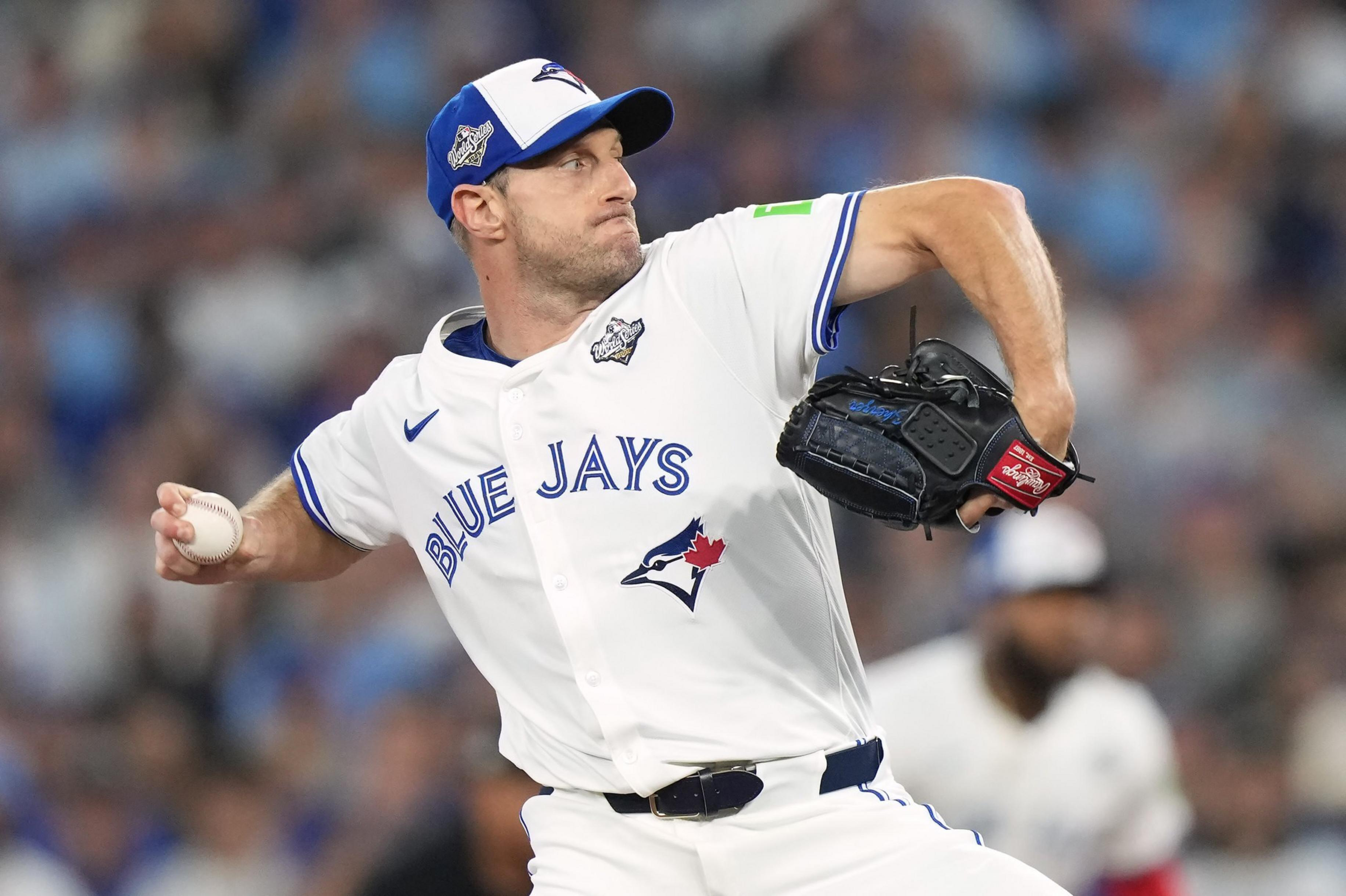 A Blue Jays pitcher in mid-throw grips the baseball tightly, wearing a white uniform and blue cap with focused determination.