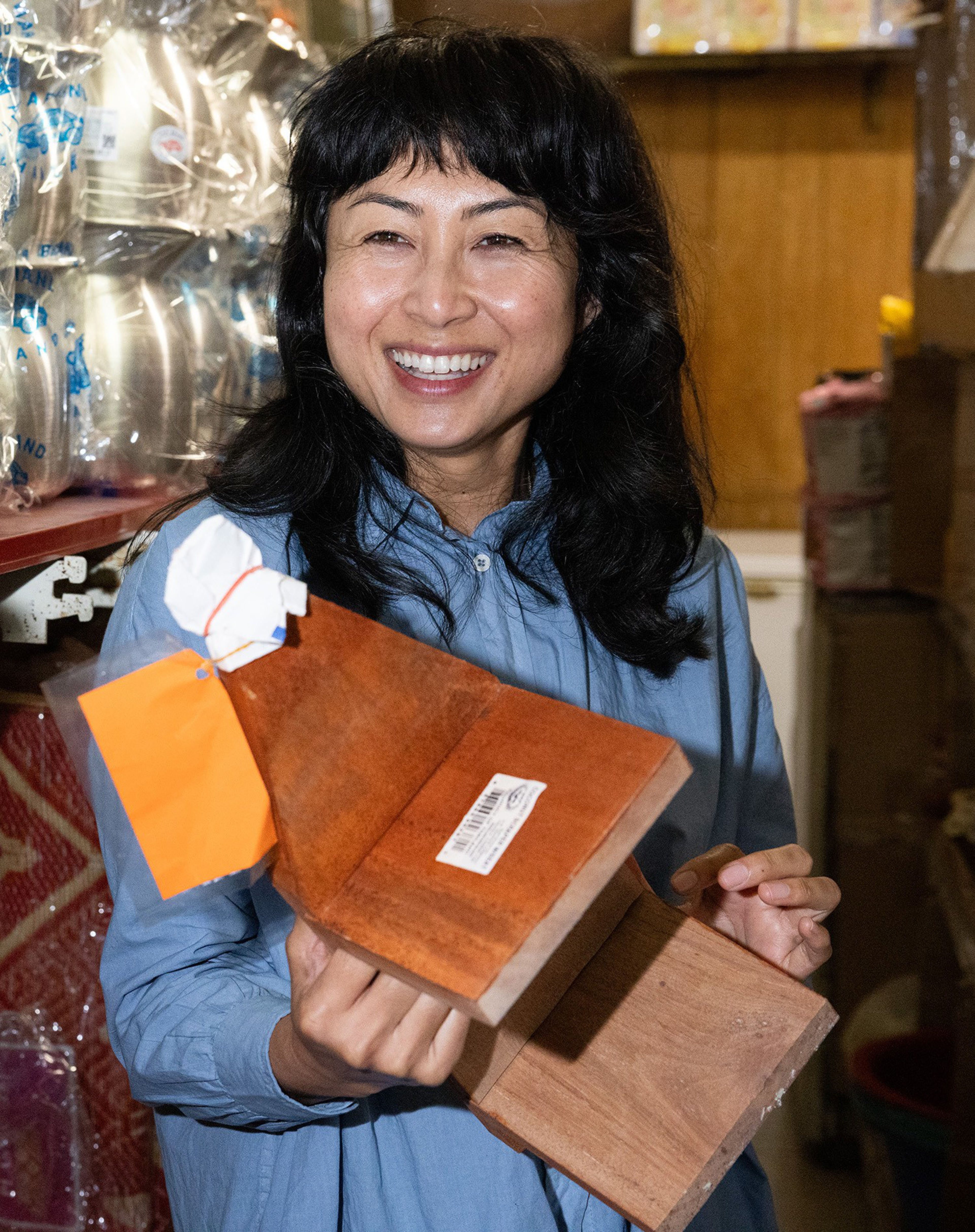 Chef Nite Yun holds up a coconut scraper bench at Battambang Market.