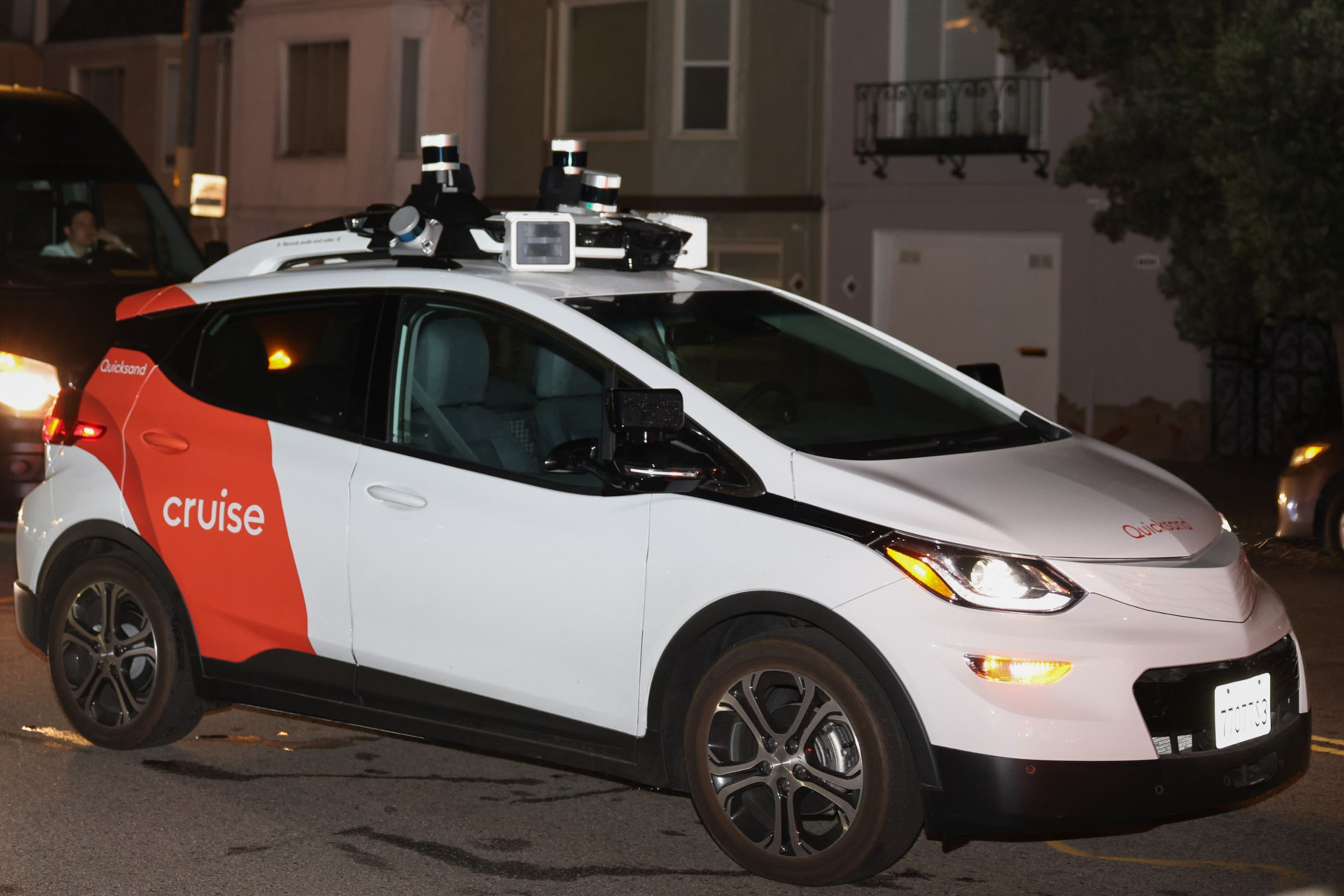A Cruise vehicle, which is a driverless, autonomous robotaxi, drives at night in San Francisco.