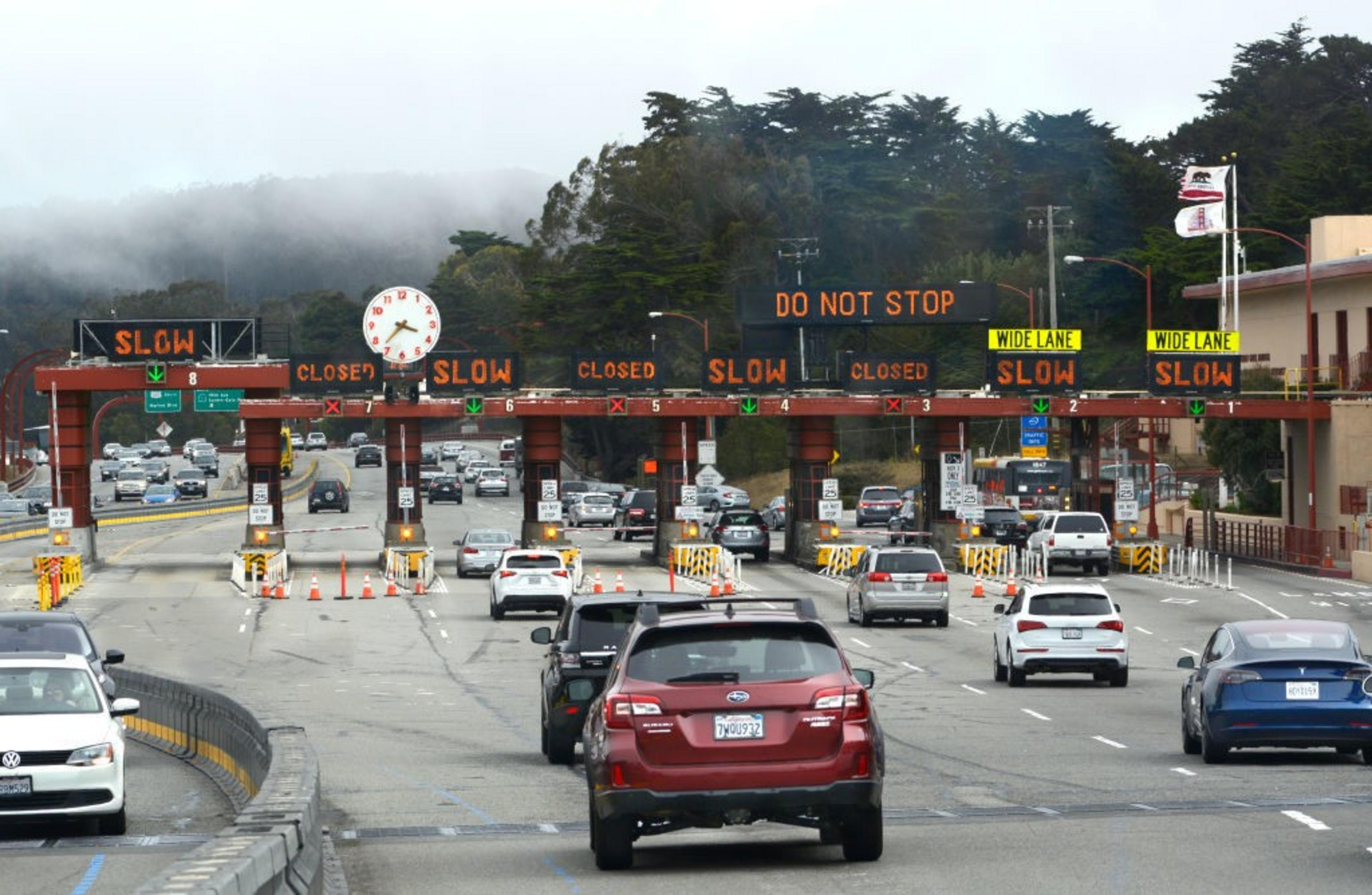 Cars approach a bridge toll plaza.