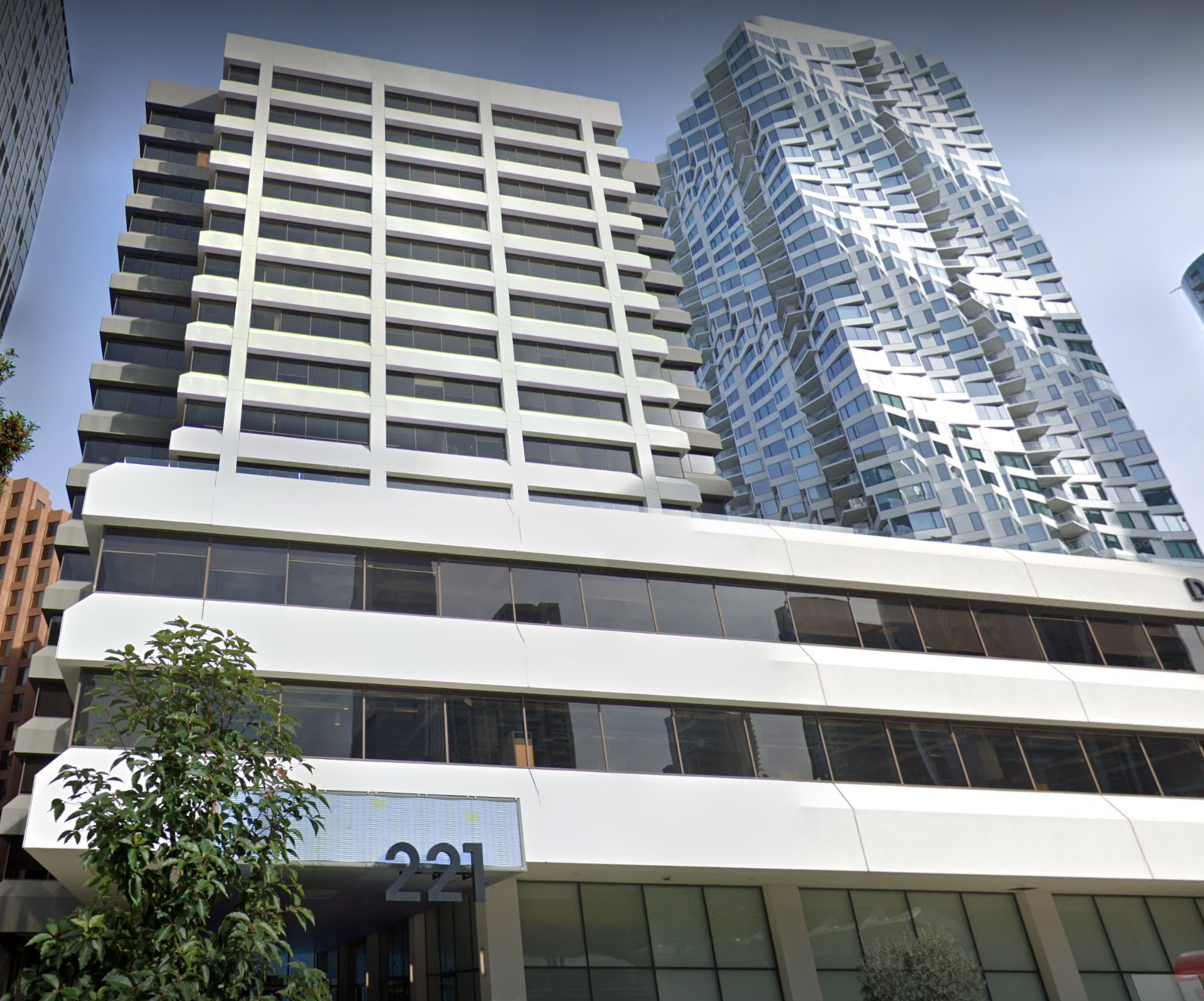 a tall white buiding is seen next to a glass skyscraper
