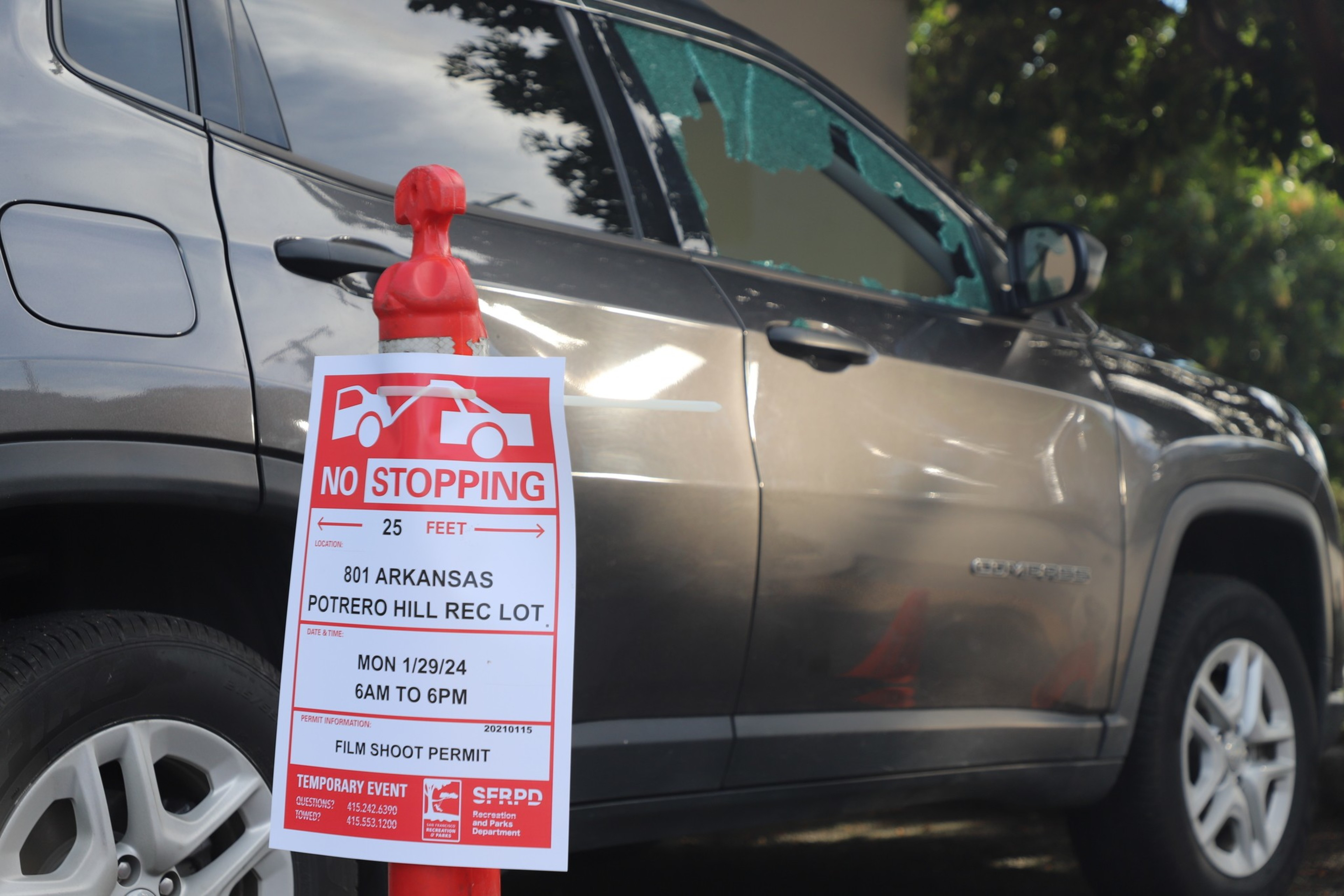 A &quot;No Stopping&quot; sign on a red stand by a silver SUV, for a film shoot permit at 801 Arkansas.