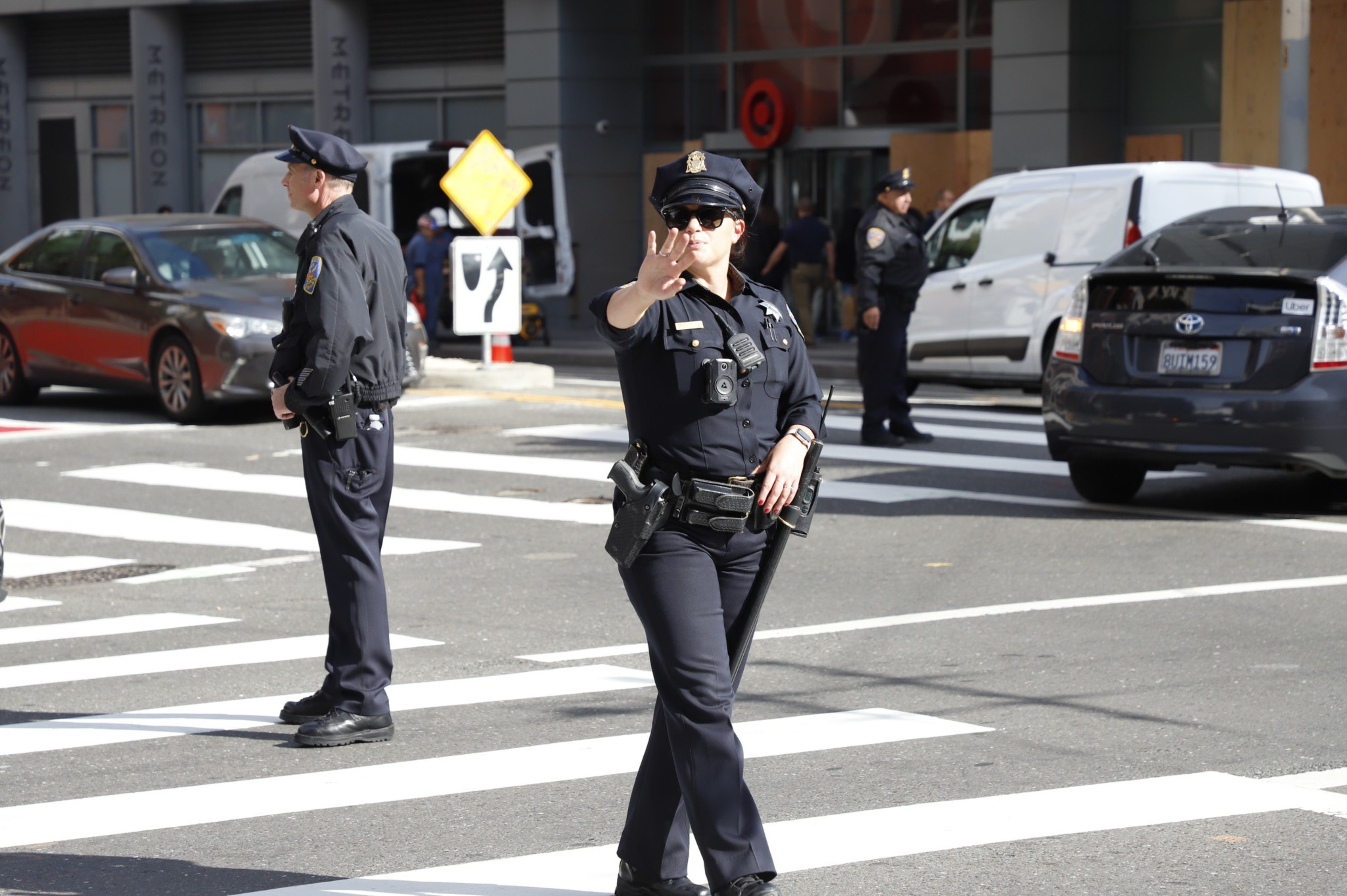 Two SFPD officer stand in the middle of the street forcing traffic to stop.