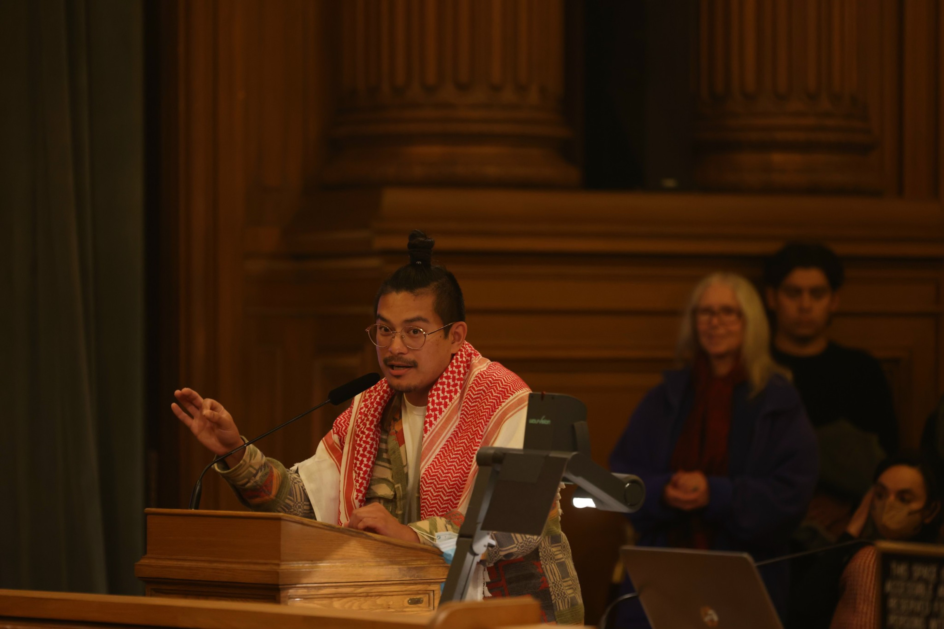 A person speaks at a podium to the Board of Supervisors. 