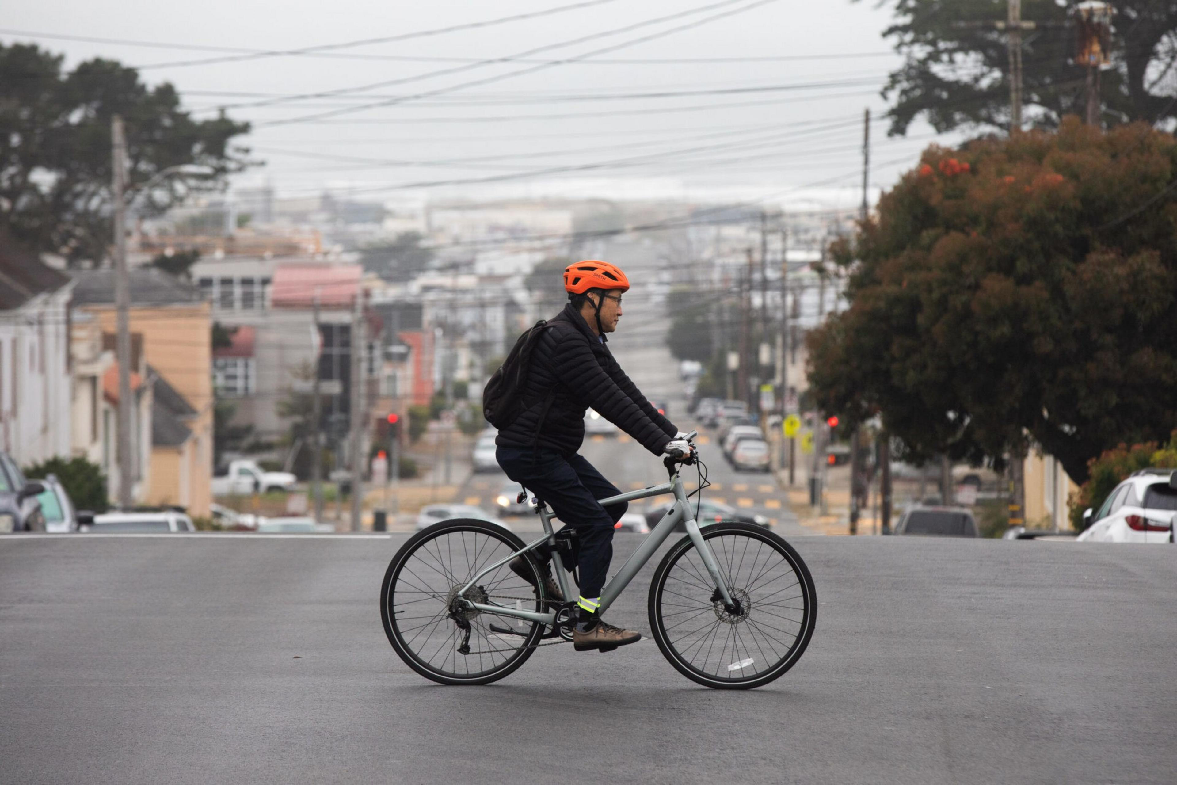 Man rides bicycle across a street