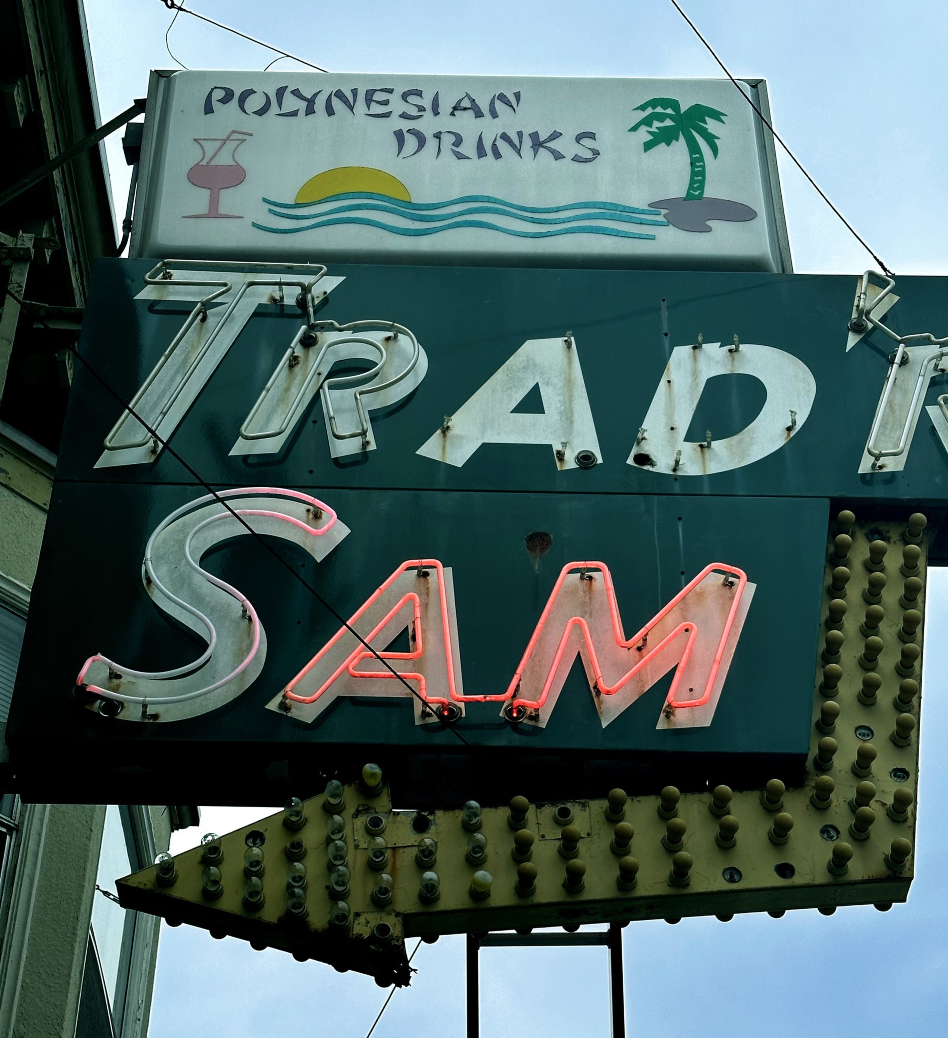 A picture of a neon sign reads Trad'r Sam, with only the &quot;Sam&quot; aglow with red neon.