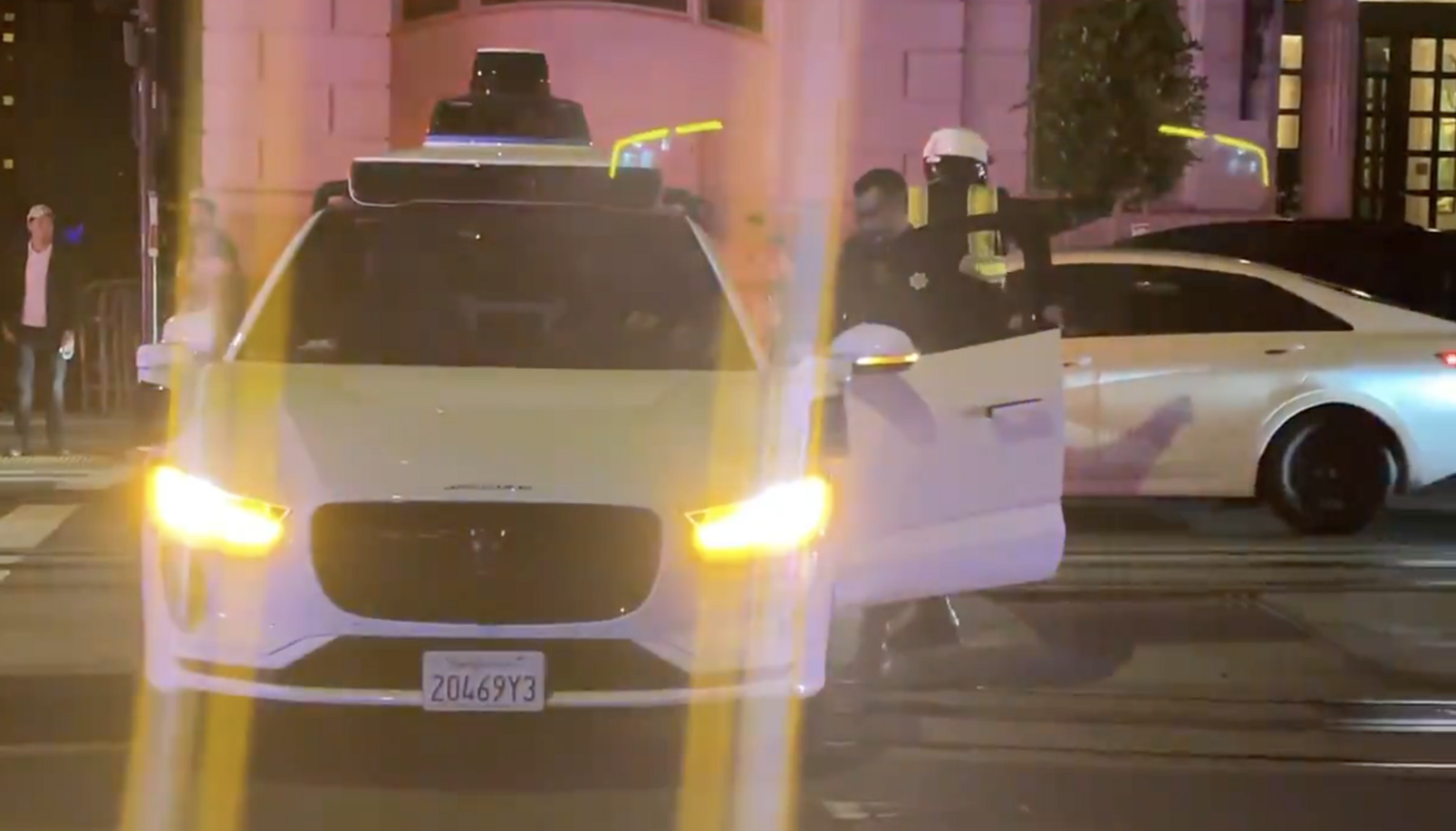 A police officer enters a Waymo car on California Street in San Francisco.