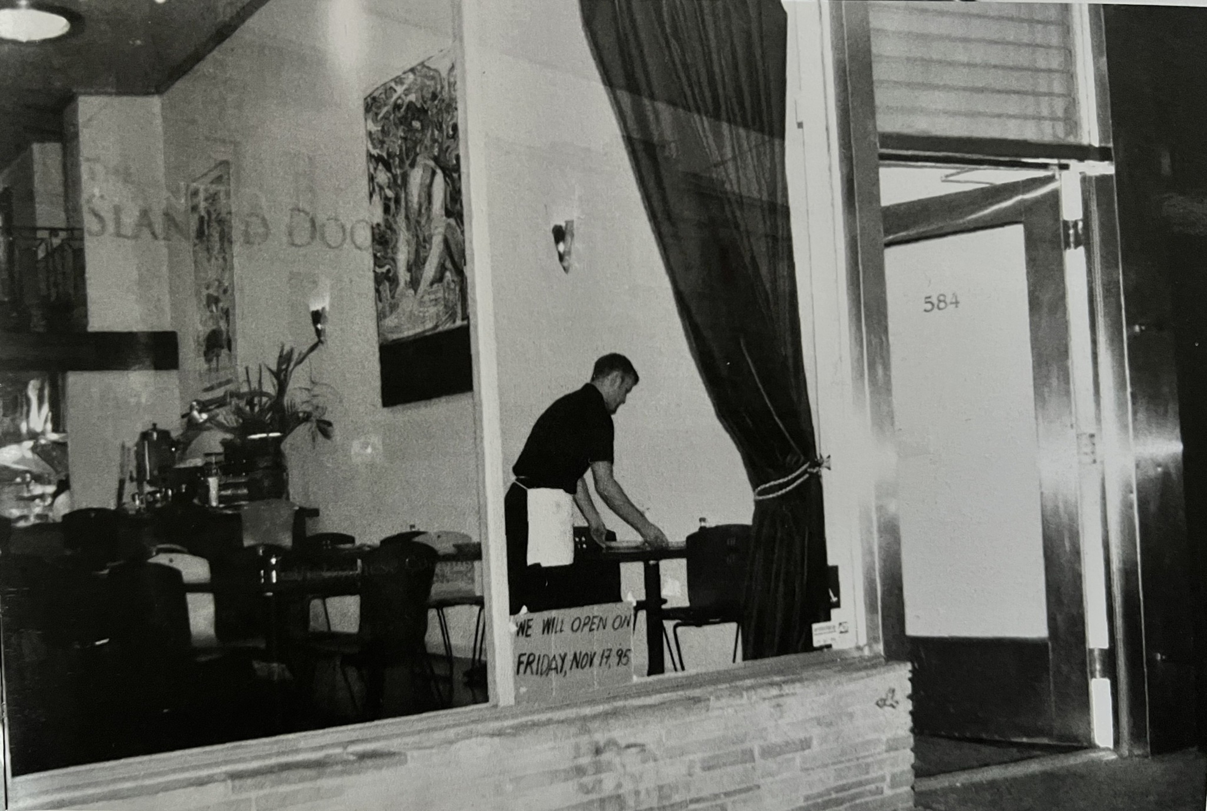 A black and white photo of 584 Valencia Street with a sign that reads &quot;The Slanted Door.&quot;