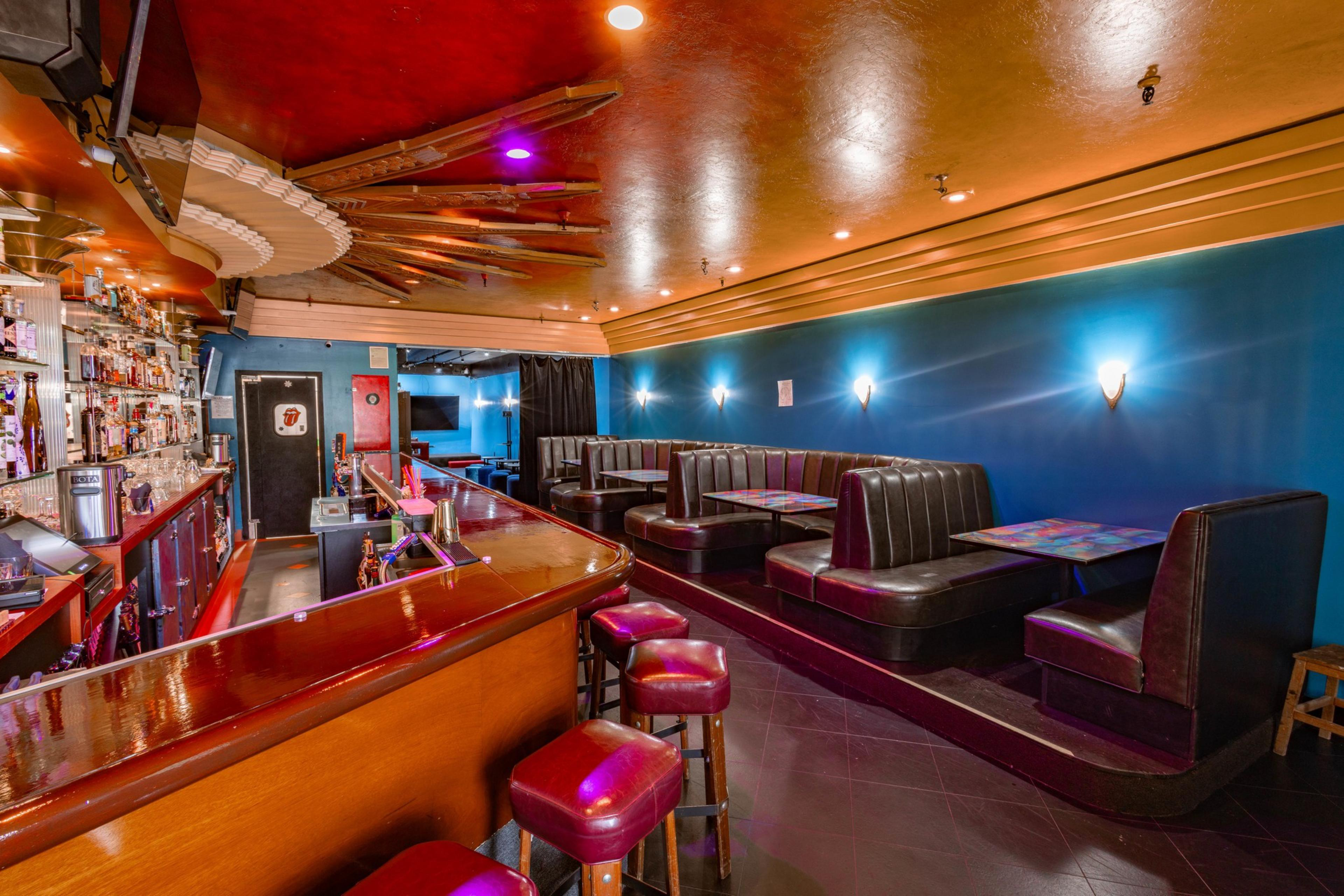 A sun-motif ceiling fixture shines down over booths and a bar.