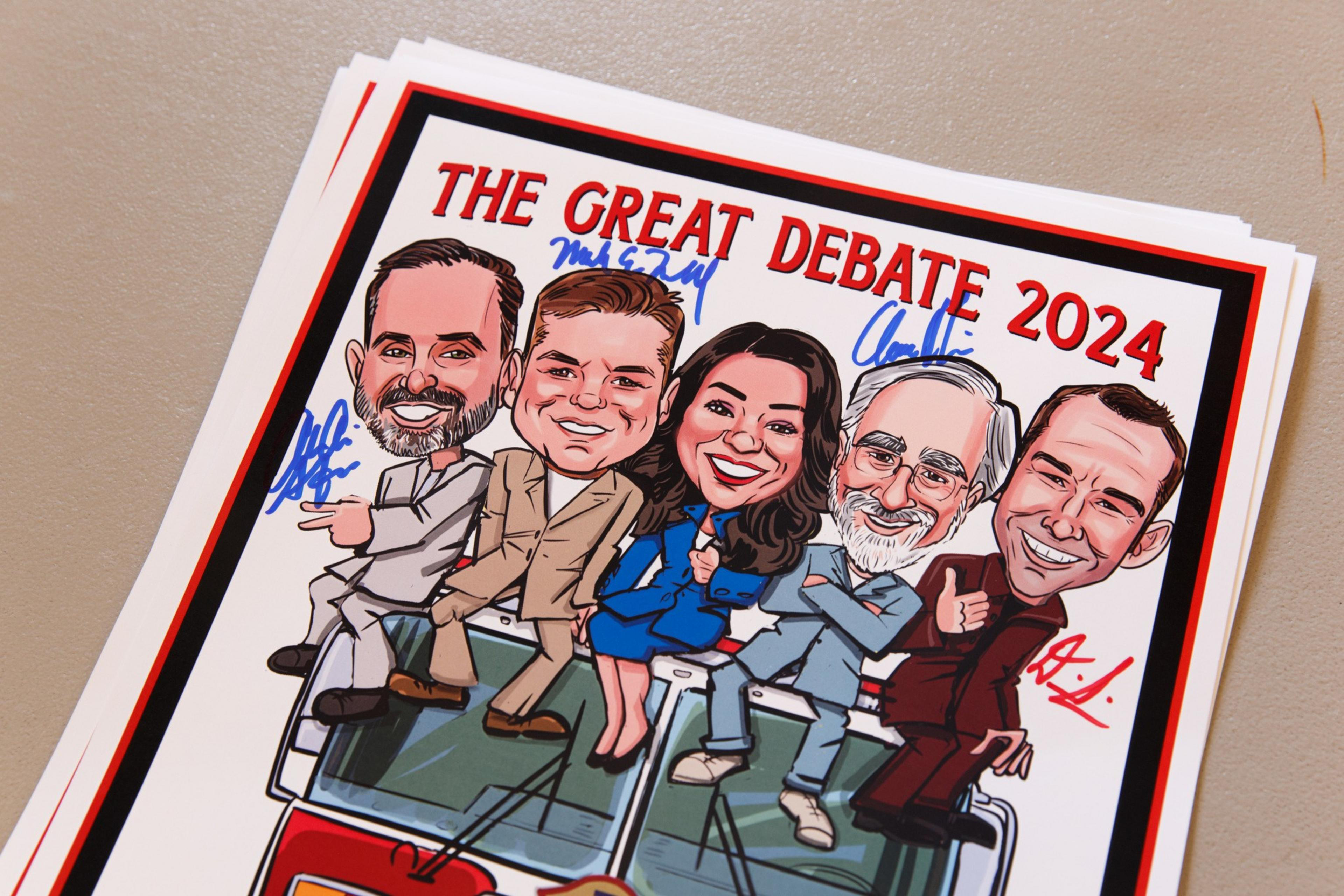 The image depicts a cartoonish drawing of five smiling people with signatures above them and red text saying &quot;The Great Debate 2024&quot; at the top.
