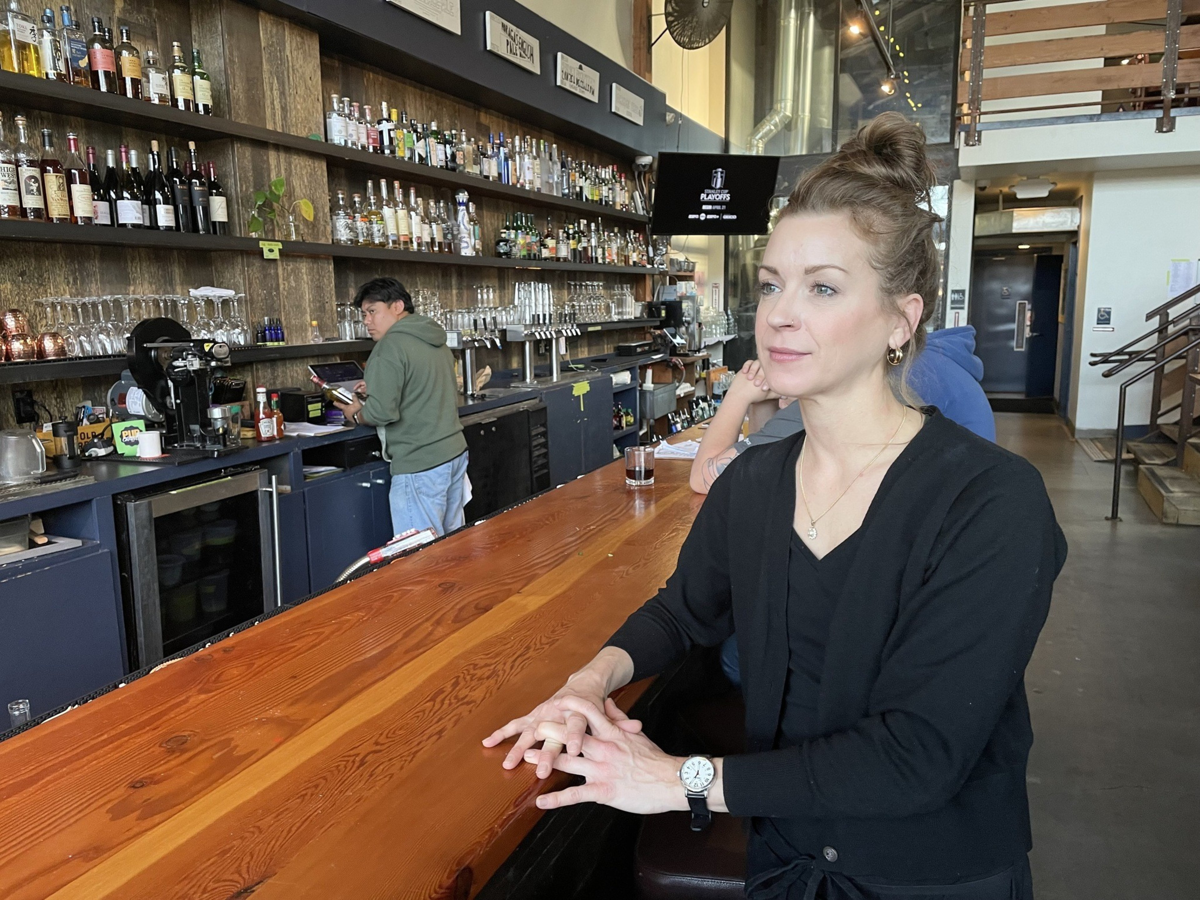 A woman sits at a bar.