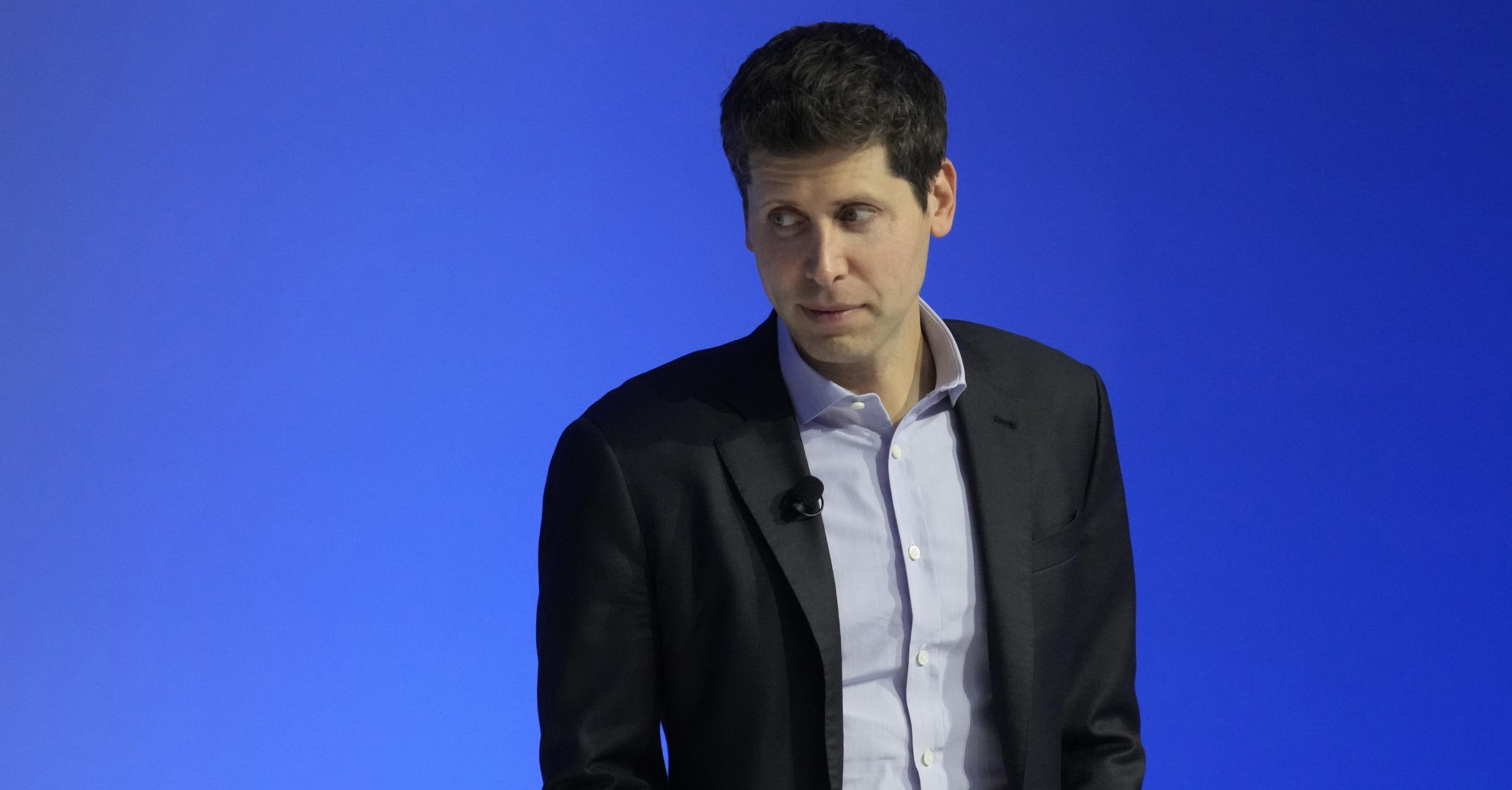 Sam Altman, CEO of OpenAI looks offscreen with a blue background.