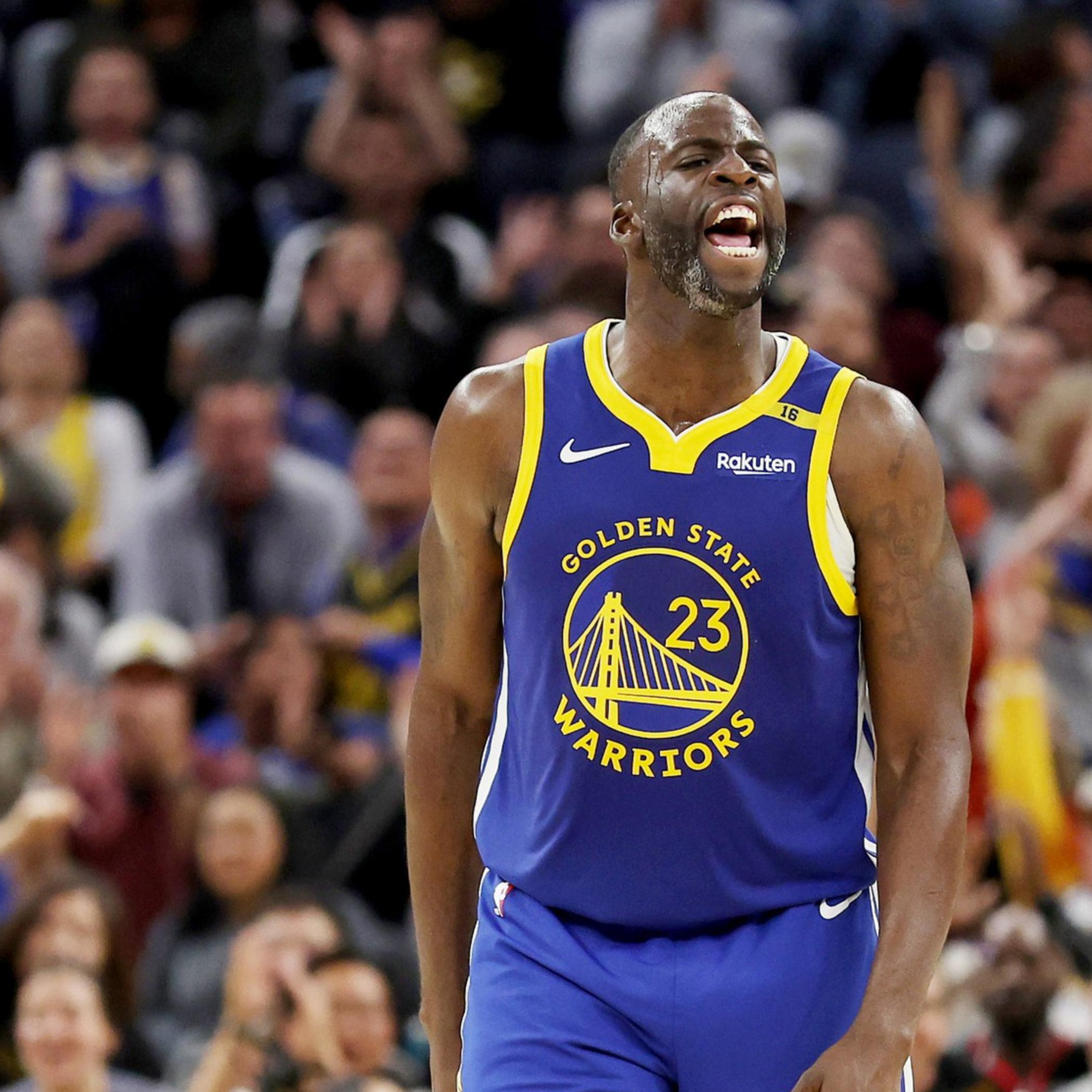 A basketball player in a Golden State Warriors jersey is on the court, yelling in excitement. The crowd behind him is cheering enthusiastically.