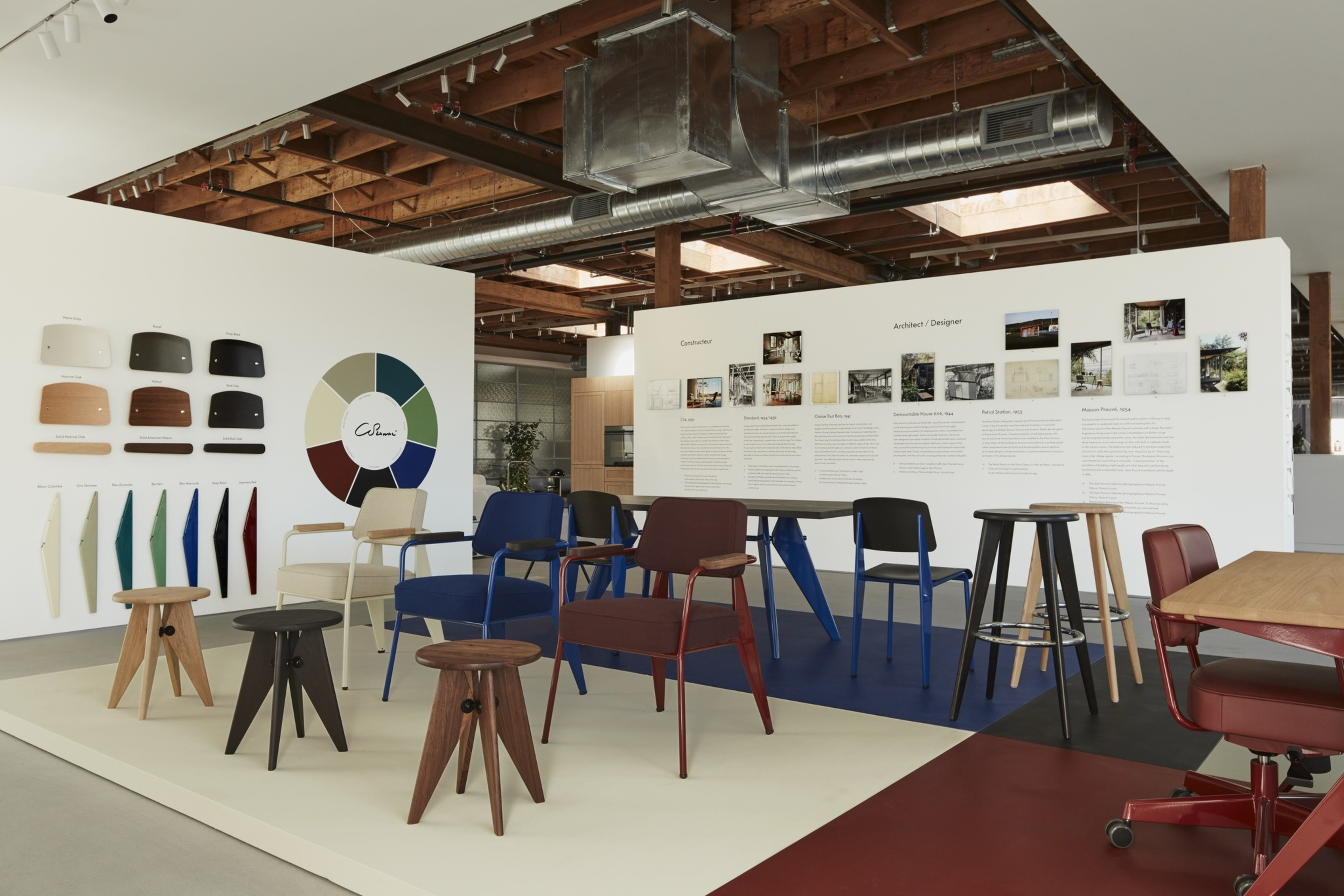Colorful modern chairs and stools by French architect Jean ProuvÃ© are lined up in temporary exhibition at Design Within Reach's San Francisco store.