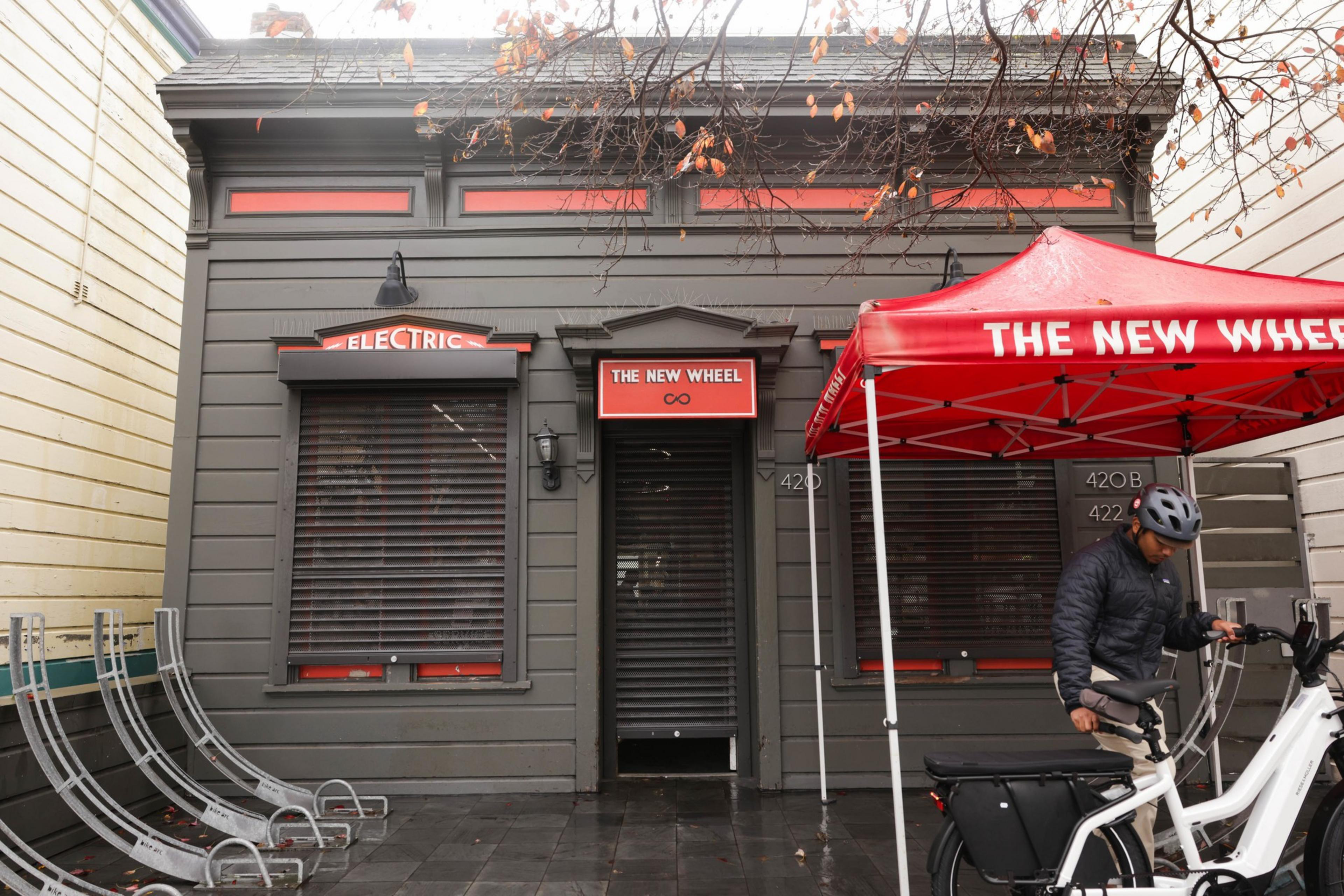Charcoal gray rolling shutters cover the windows and door at a storefront