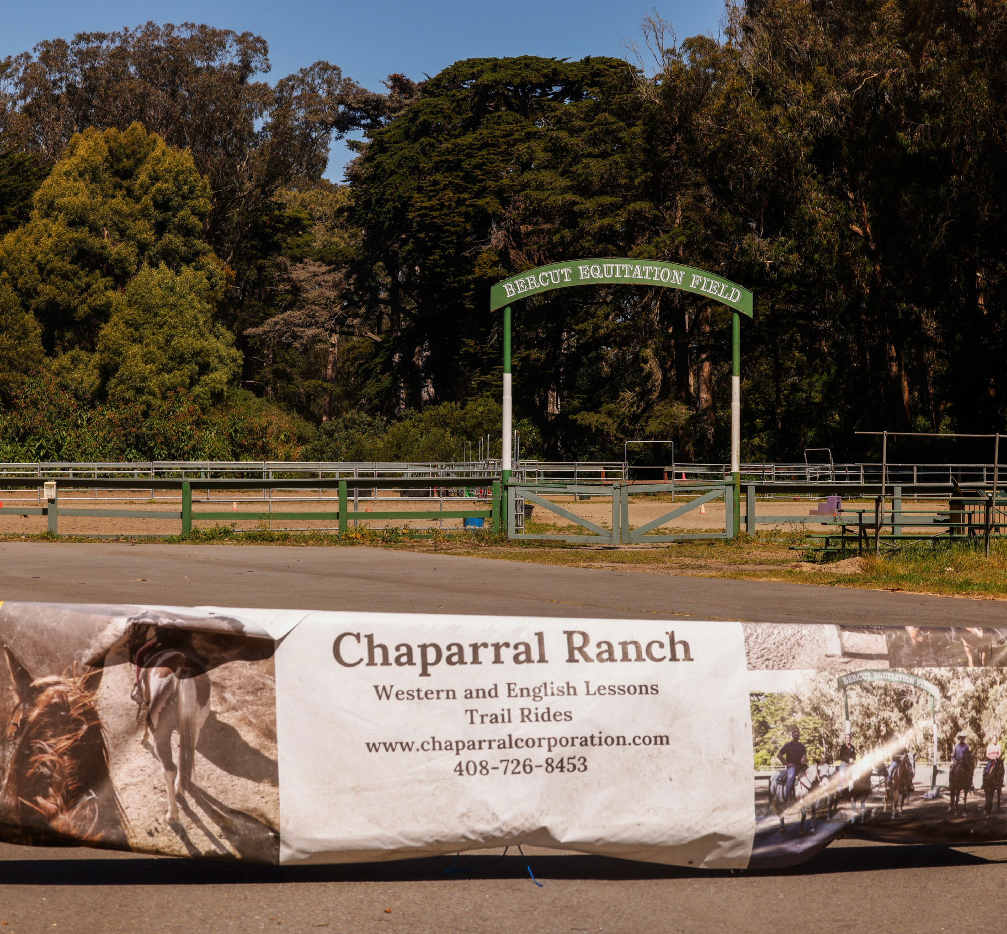 The image shows an arch labeled "Bercut Equitation Field" at the entrance to an equine field framed by trees, and a weathered banner for "Chaparral Ranch" in the foreground.