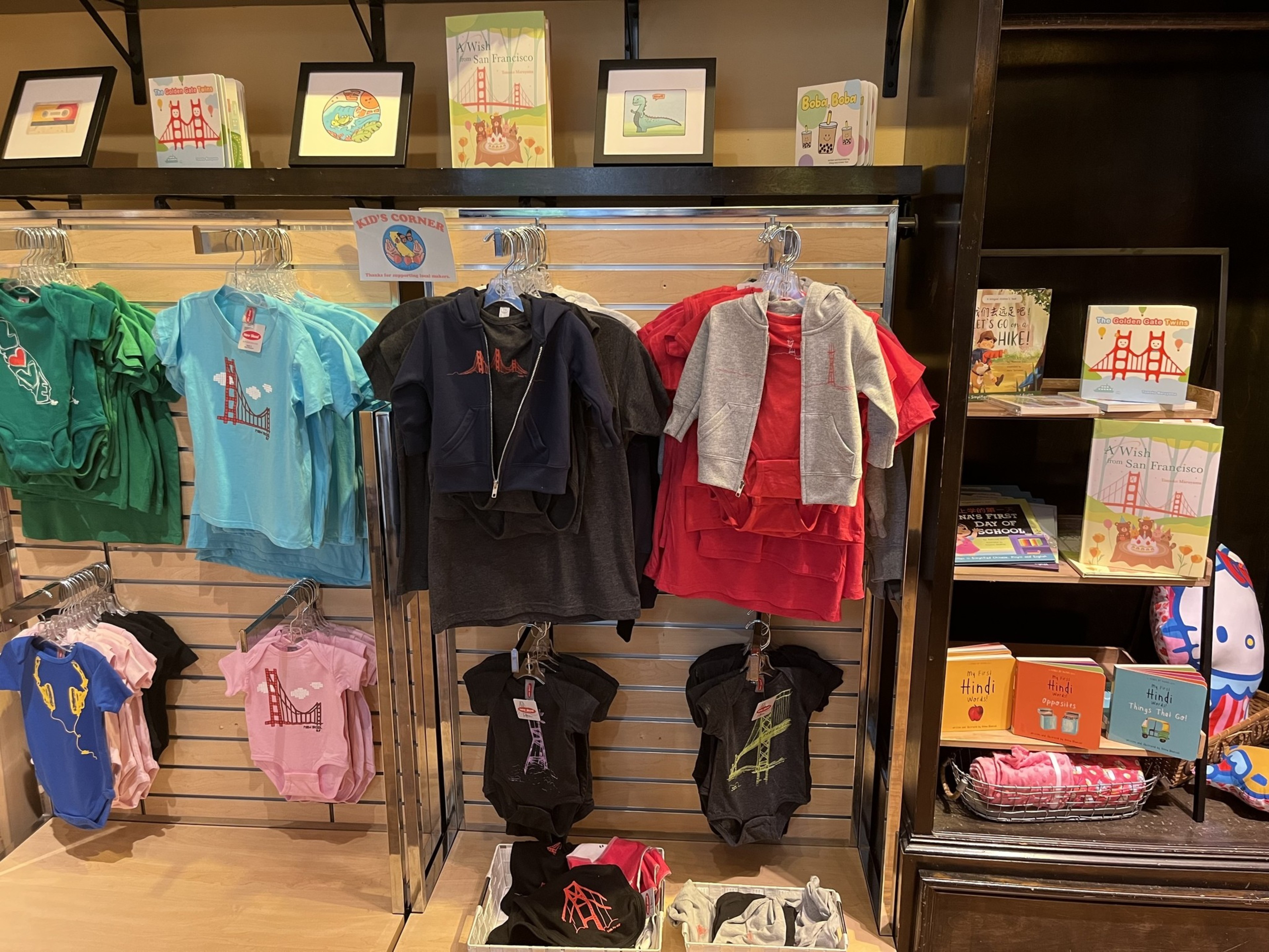 Kids clothes in different colors at a store.