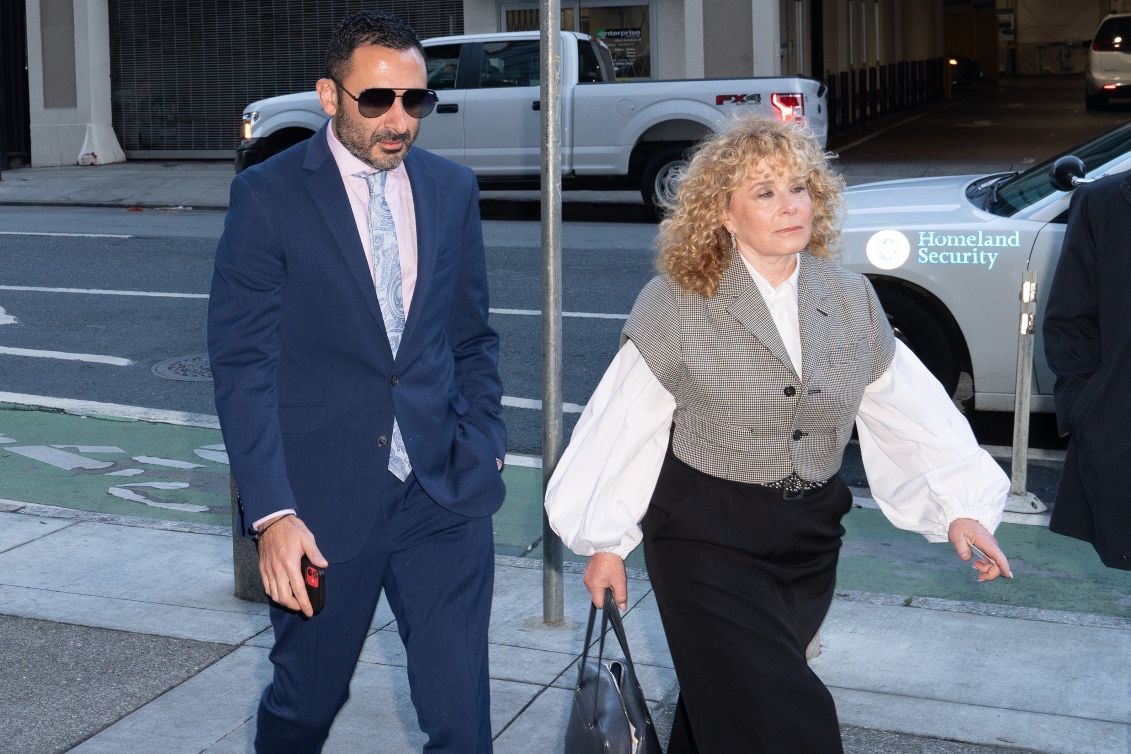 A man and woman arrive at a courthouse.