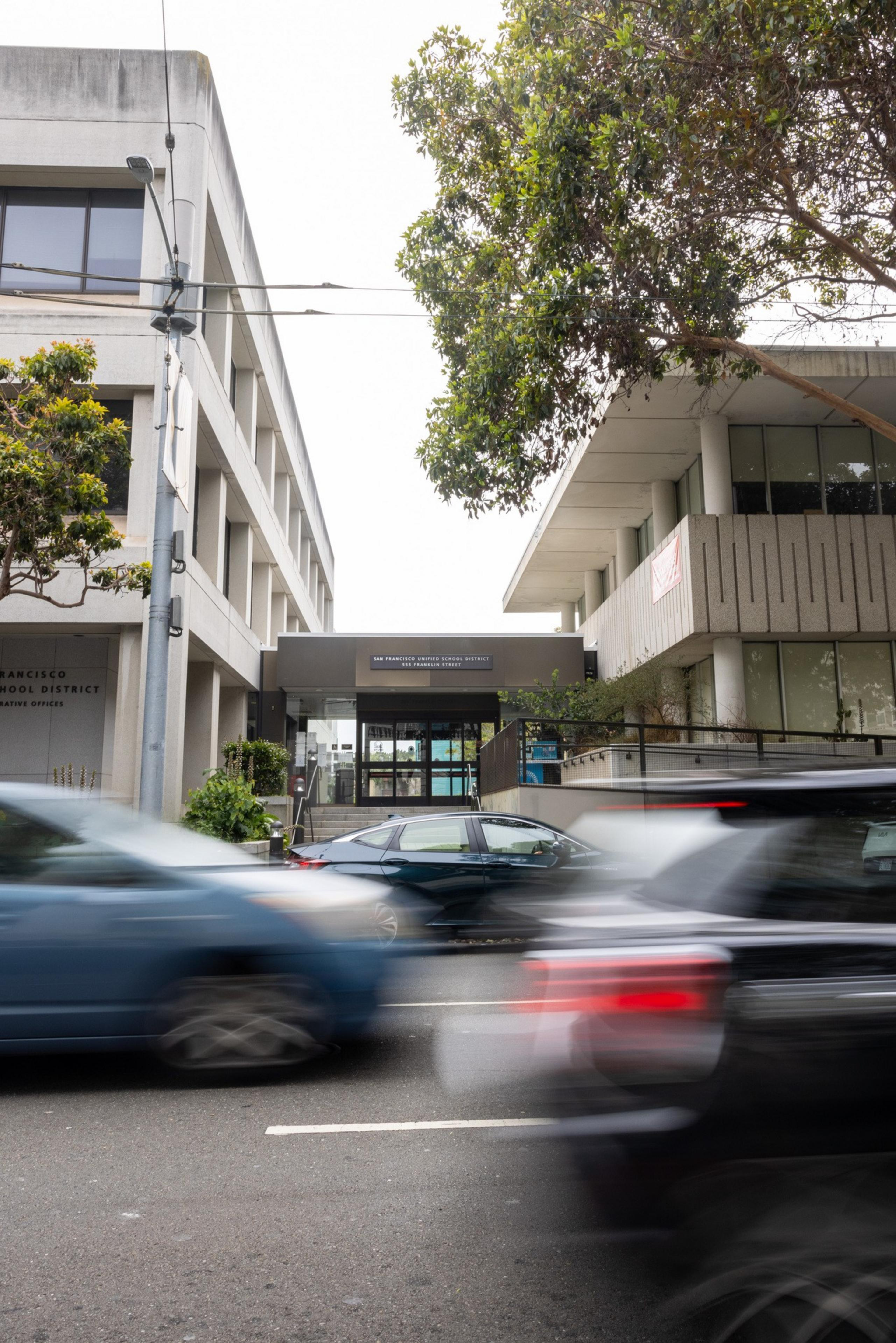 Cars pass in front of the SFUSD administrative offices.