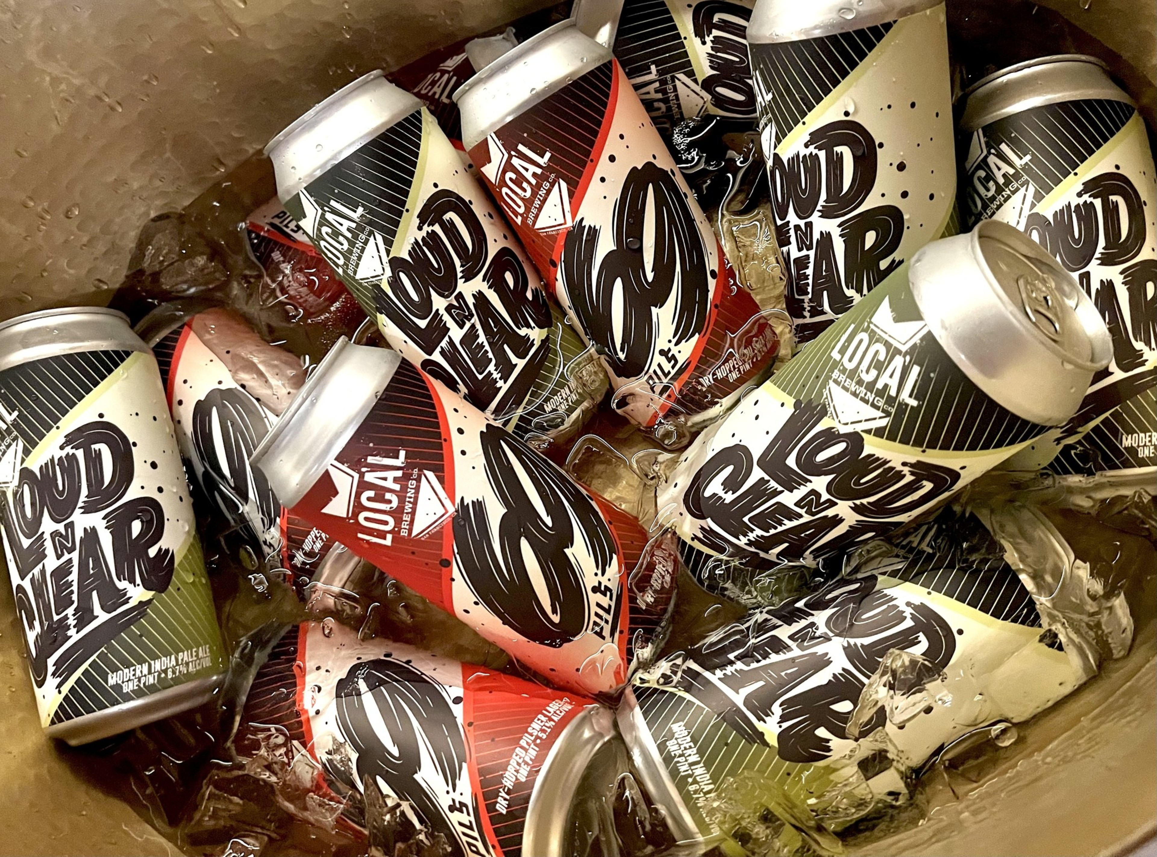 Cans of "Loud n Near" beer by Local Brewing, including Modern India Pale Ale and 60 Pils, chilled in a container filled with ice.