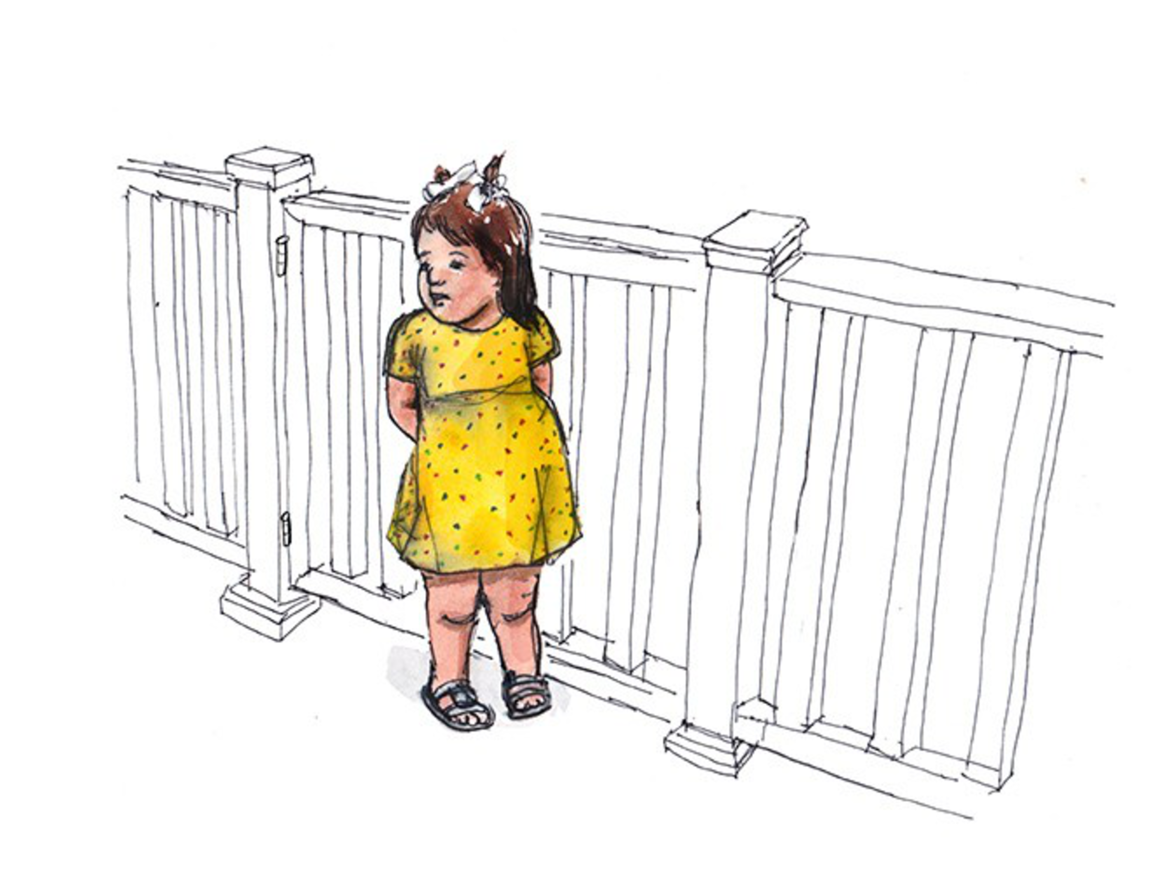 A young girl in a yellow dress with polka dots stands with hands behind her back near a white fence, looking slightly to her left.