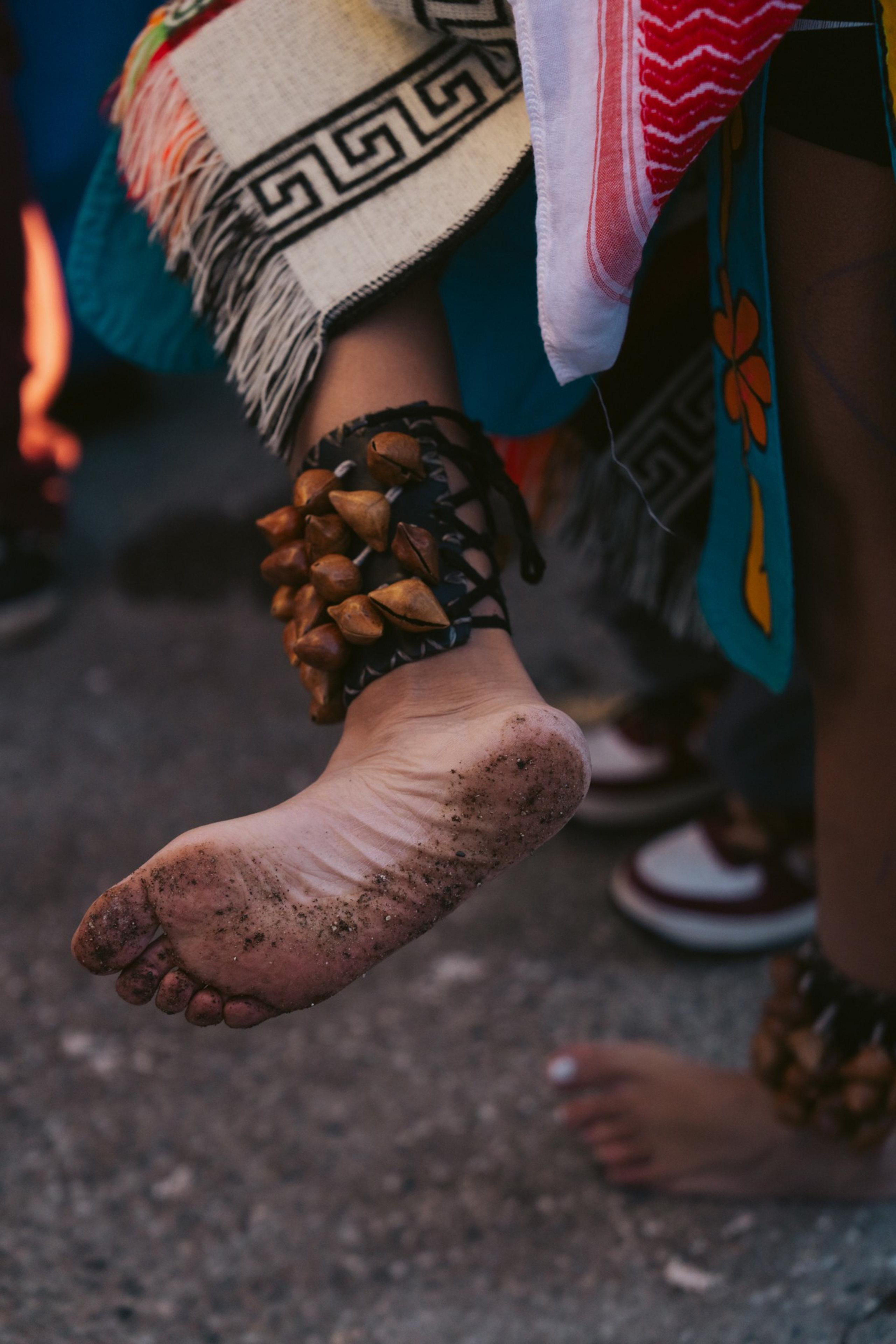 Frida Ortega inspects her feet before her performance with the Mexica dance group.