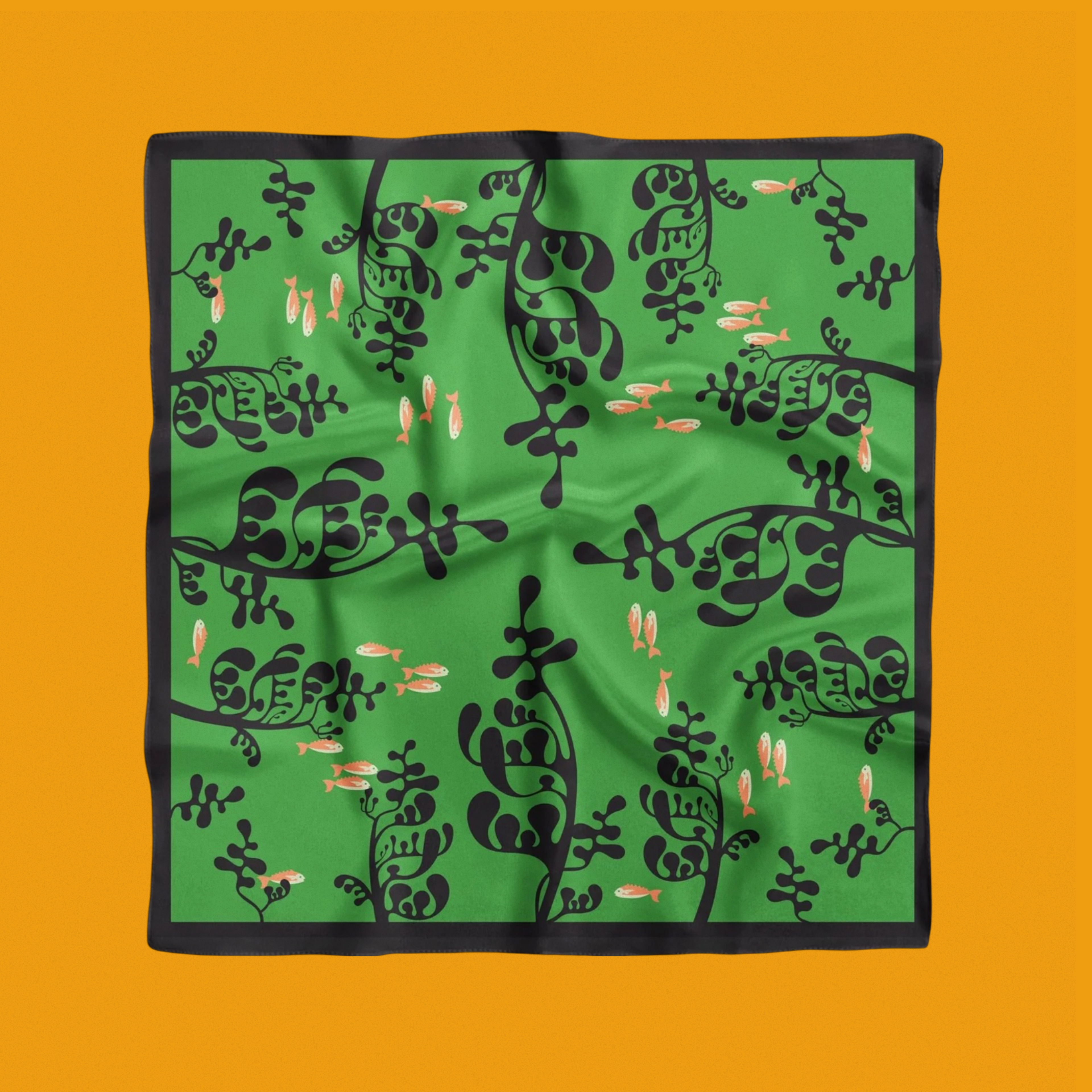 A green scarf features a pattern of black abstract plant-like shapes and small orange fish. The background is vibrant orange, framing the scarf.