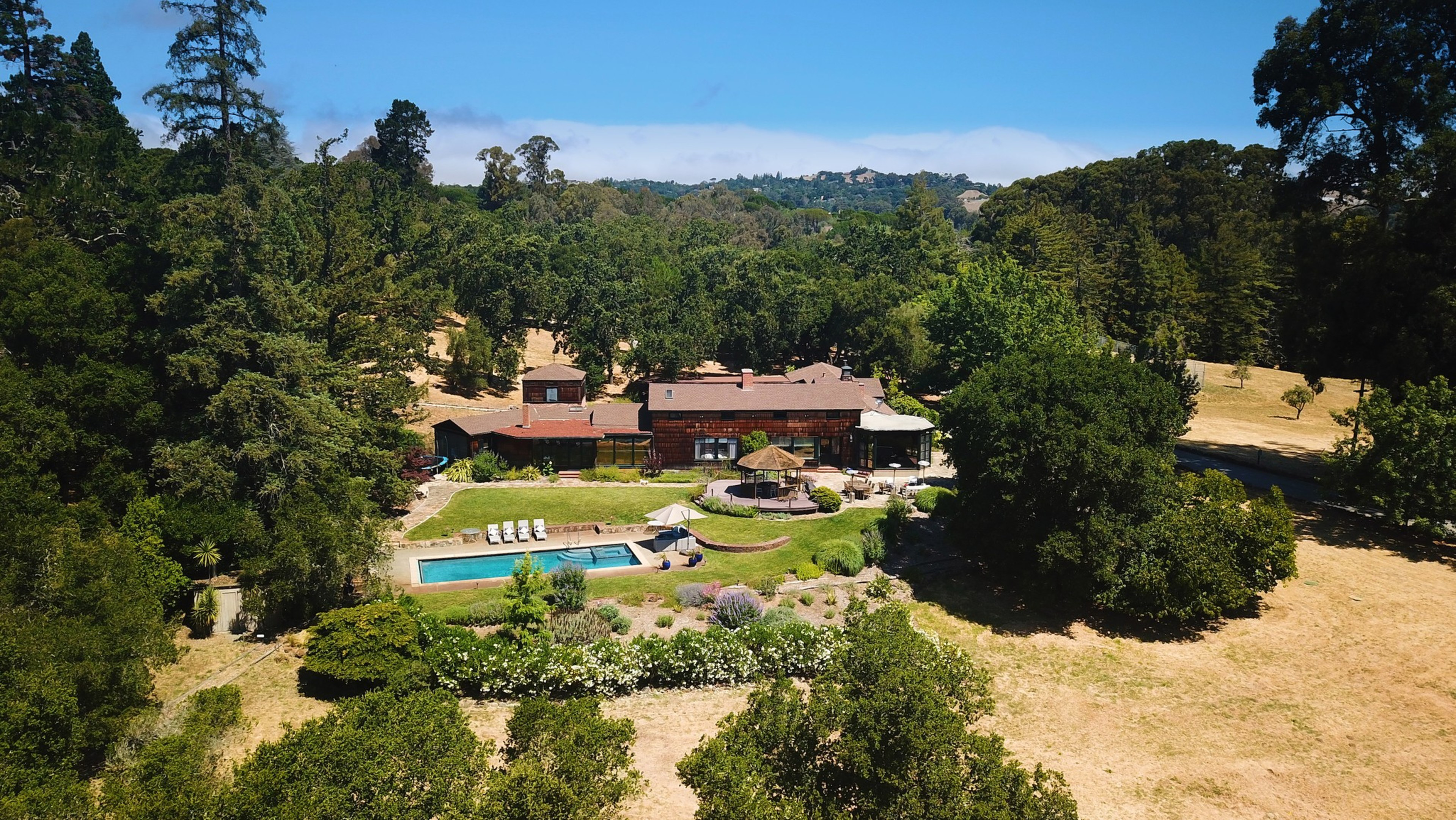 A house surrounded by trees with a pool.