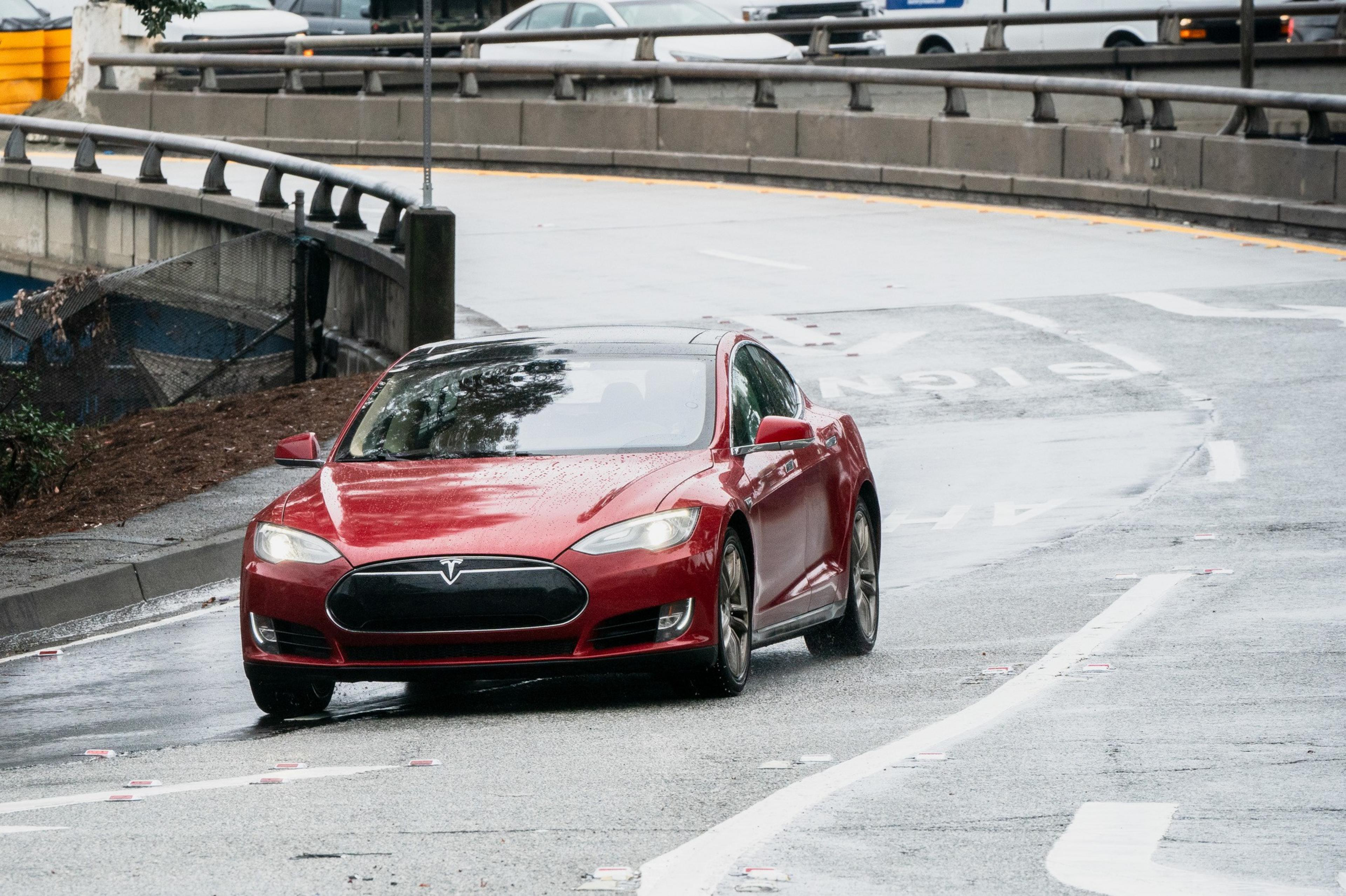 A red Tesla Model S with no front license plate.