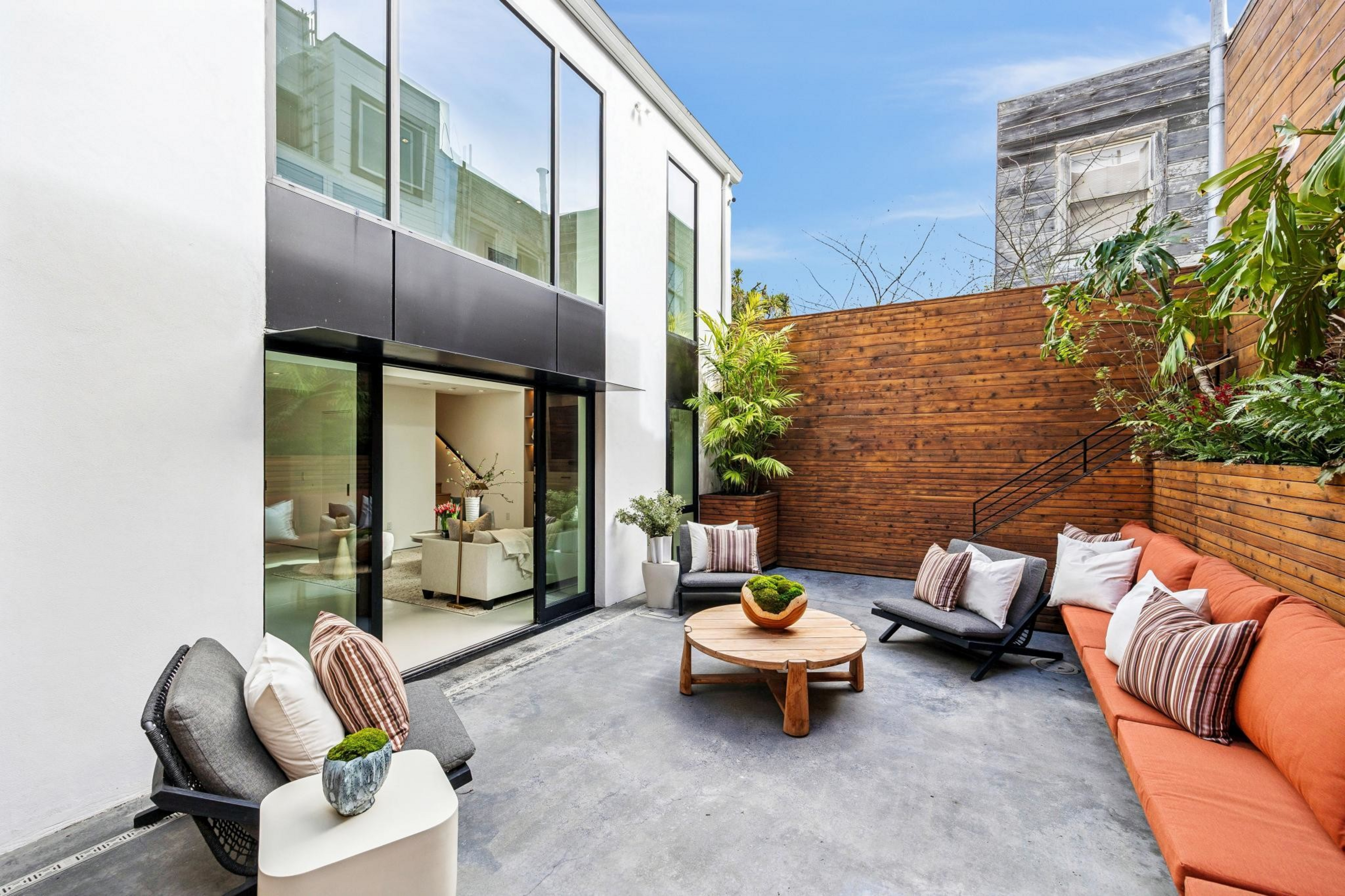 Modern outdoor patio with concrete floor, wooden fence, orange ...