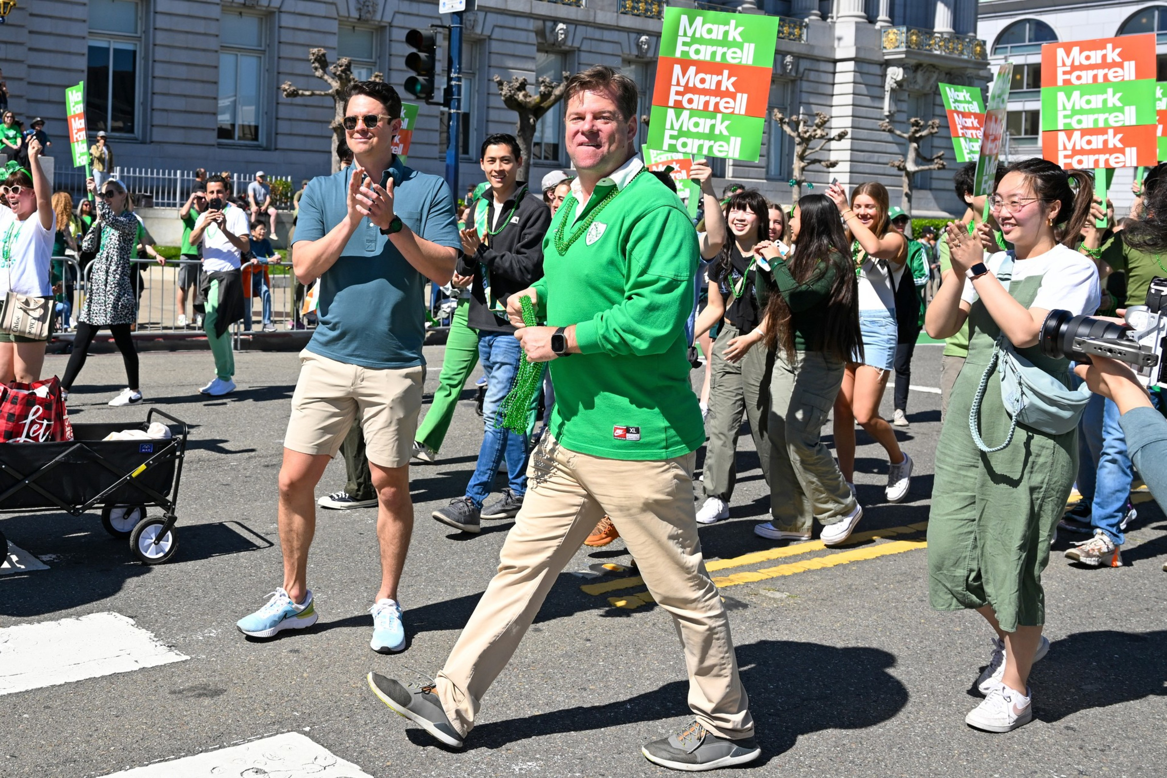 Mark Farrell walks with a group of people at a parade.