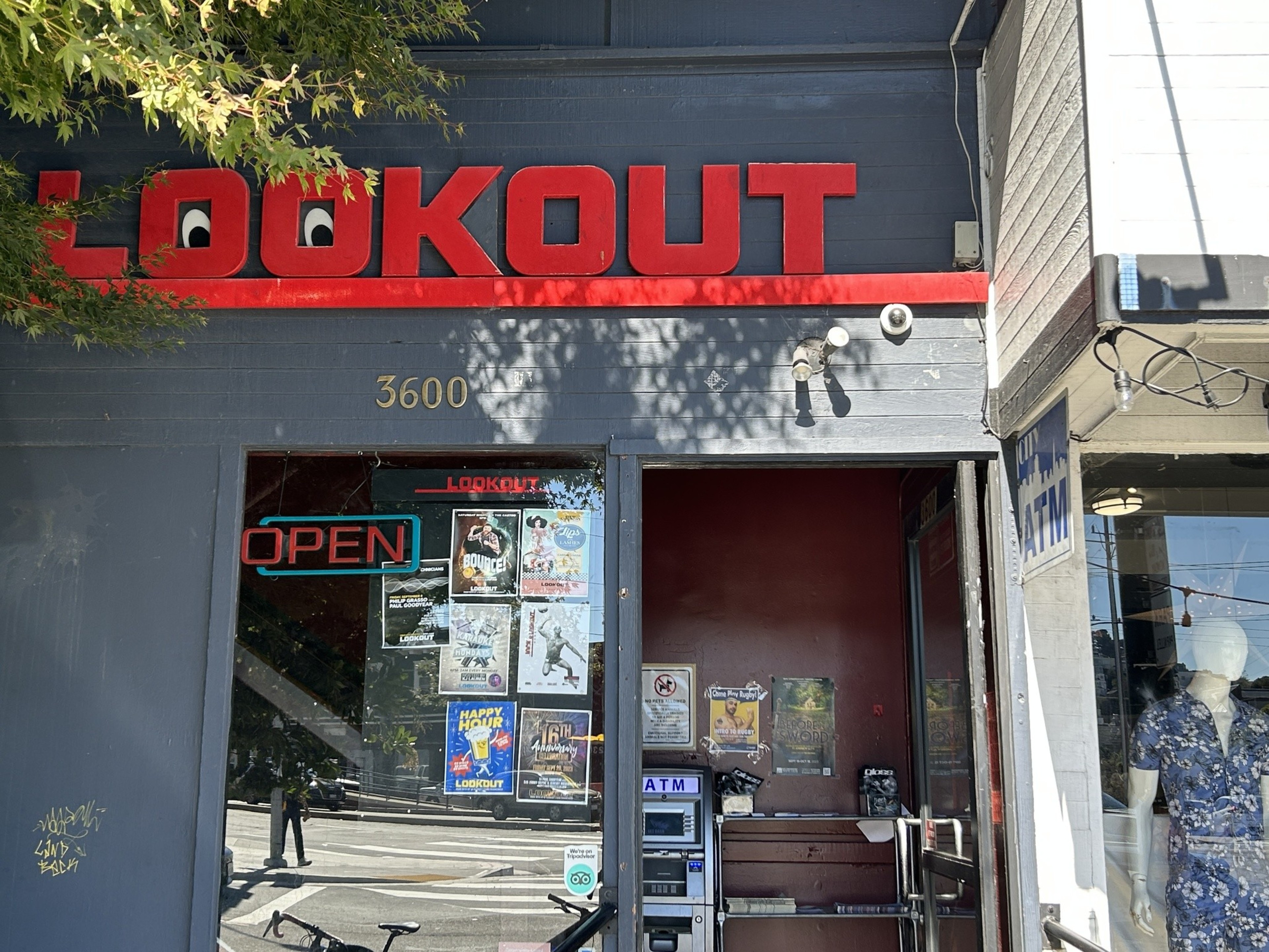 Bright red sign says LOOKOUT on building storefront